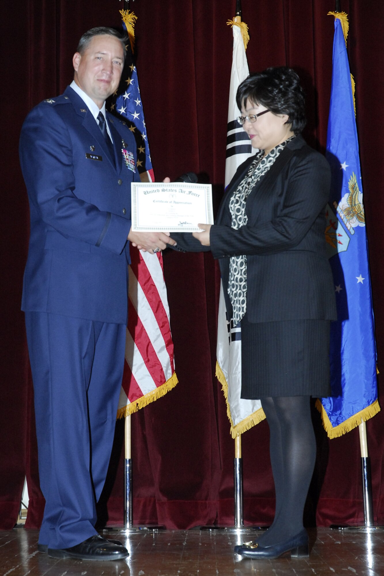 OSAN AIR BASE, Republic of Korea--  Ms. Sunah Ji, an education technician with the 51 Mission Support Squadron, is congratulated by Col. Jon A. Norman, the 51st Fighter Wing commander, for her selection the as Air Force Education and Training Manager of the Year (Cat IV-D). (Photo by: Tech. Sgt. Scott A Labuda)
