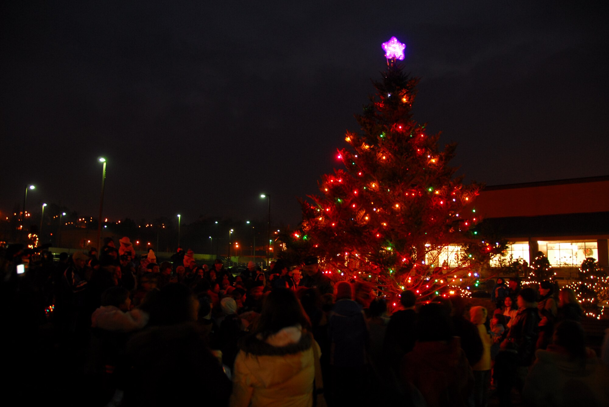 OSAN AIR BASE, Republic of Korea --  Members of Team Osan gather around the just-lit Christmas tree in front of the base theater Dec. 6. AAFES sponsored a holiday celebration, with a free movie and a visit from Santa. (U.S. Air Force photo by Staff Sgt. Ronnie Hill)