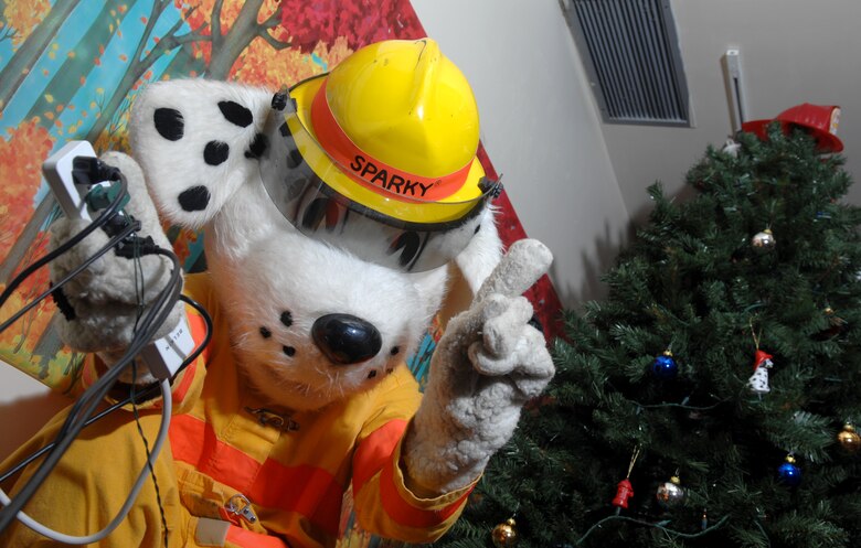 Sparky the Fire Dog, played by Airman 1st Class Damien Montero, 36th Civil Engineering Squadron, says no to bad safety practices during the holidays. Holiday lights may look pretty, but they can also cause fires. If lights have cracked or frayed cords, throw them away. Be sure artificial Christmas trees are labeled “flame retardant.” Water real Christmas trees several times a day. And make sure it doesn't block the room exit.   (U.S. Air Force photo/ Senior Airman Miranda Moorer)                                        