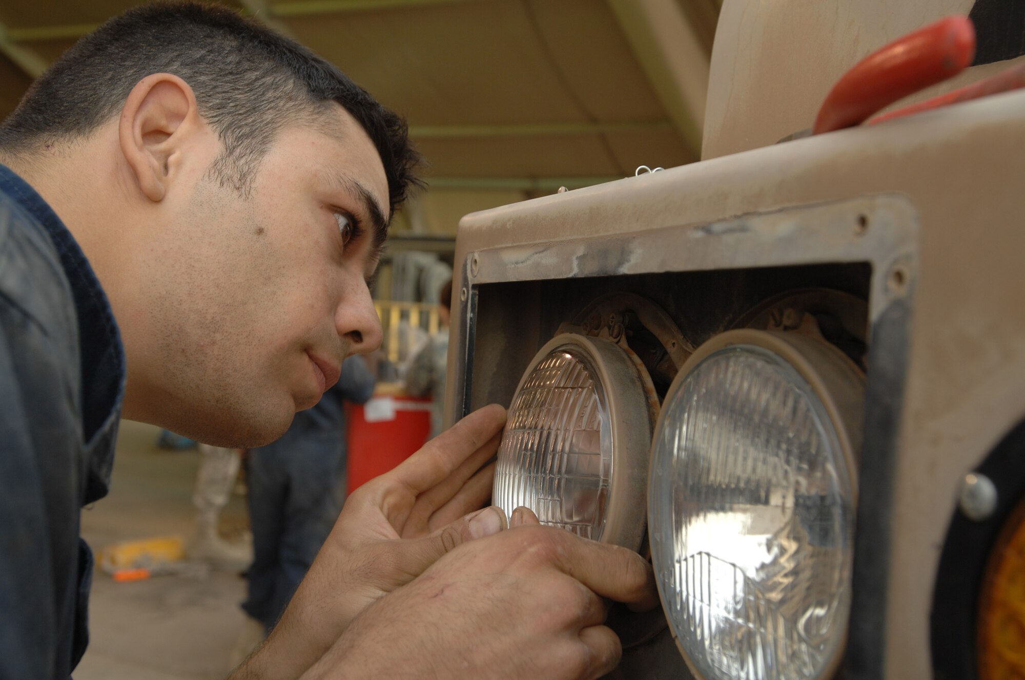 ALI AIR BASE, Iraq -- Staff Sgt. Shawn Rhoden replaces a headlight on a fire truck Dec. 4. Airmen of the 407th Expeditionary Logistic Readiness Squadron vehicle maintenance are responsible for maintaining, repairing, rebuilding, or replacing defective parts as well as completing preventative maintenance actions on all special purpose, base maintenance, refueling, fire fighting, and material handling vehicles and equipment. Sergeant Rhoden is deployed from Eielson Air Force Base, Alaska. (U.S. Air Force photo/Airman 1st Class Jonathan Snyder)