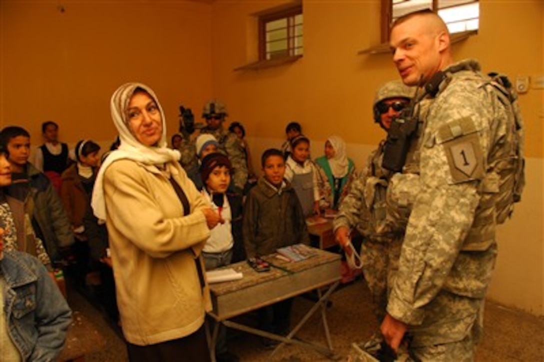 U.S. Army 1st Lt. Quinn Robertson meets students and their head mistress during a school assessment in the Yarmuk neighborhood of Baghdad, Iraq, on Nov. 27, 2007. Assessments help determine the needs of local schools so coalition forces may help the restoration of vital infrastructure within the area.  Robertson is attached to the Civil Military Operations Company, 2nd Battalion, 32nd Field Artillery Regiment, attached to 2nd Brigade Combat Team, 1st Cavalry Division.  