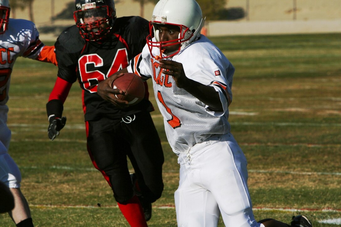 Charles Jefferson, Headquarters Battalion quarterback, uses his field vision and agility to find the holes in Miramar?s defense at the Best of the West Football Championship at Felix Field Dec. 8.
