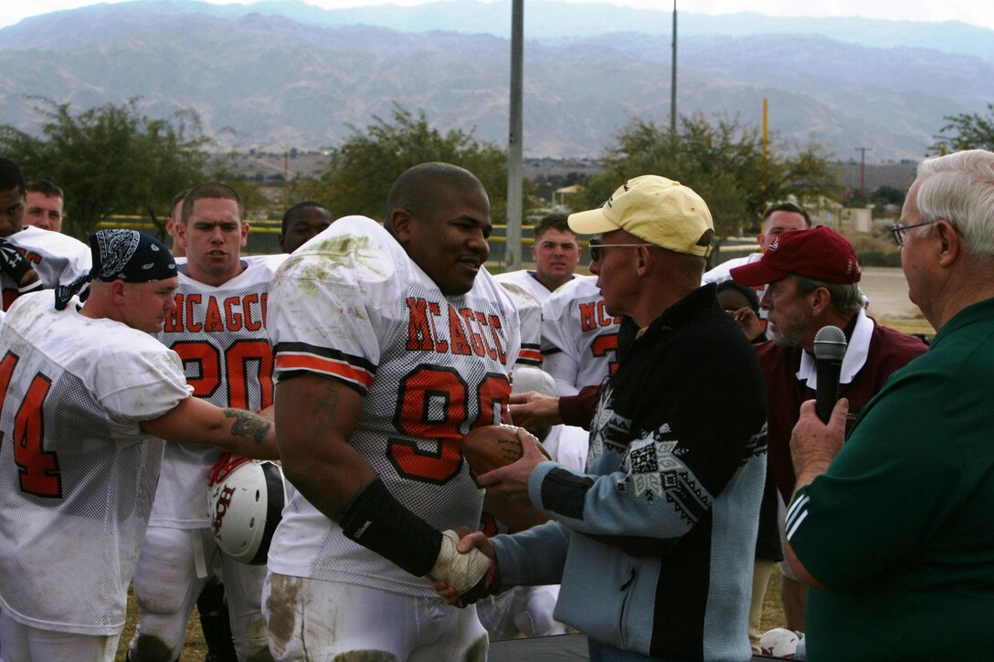 Brig. Gen. Melvin G. Spiese presents Johnnie Sanders, Headqurters Battalion defensive coach and middle linebacker, with the team?s most valuable player award at the Best of the West Football Championship at Felix Field Dec. 8.