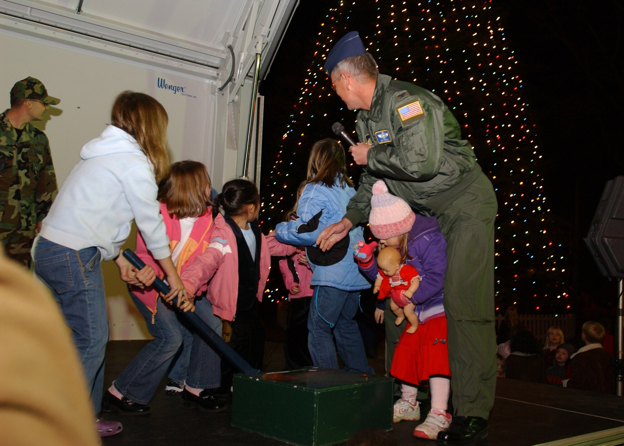 YOKOTA AIR BASE, Japan - Colonel Jeff Newell, commander of the 374th Airlift Wing, and a number of children pull the switch to turn on the Yokota Christmas Tree on December 6, 2007.  This was the finale of a ceremony that included singing from the Yokota Community Choir and a visit from Santa Claus. (U.S. Air Force photo by Airman First Class Jonathan Fowler)             
