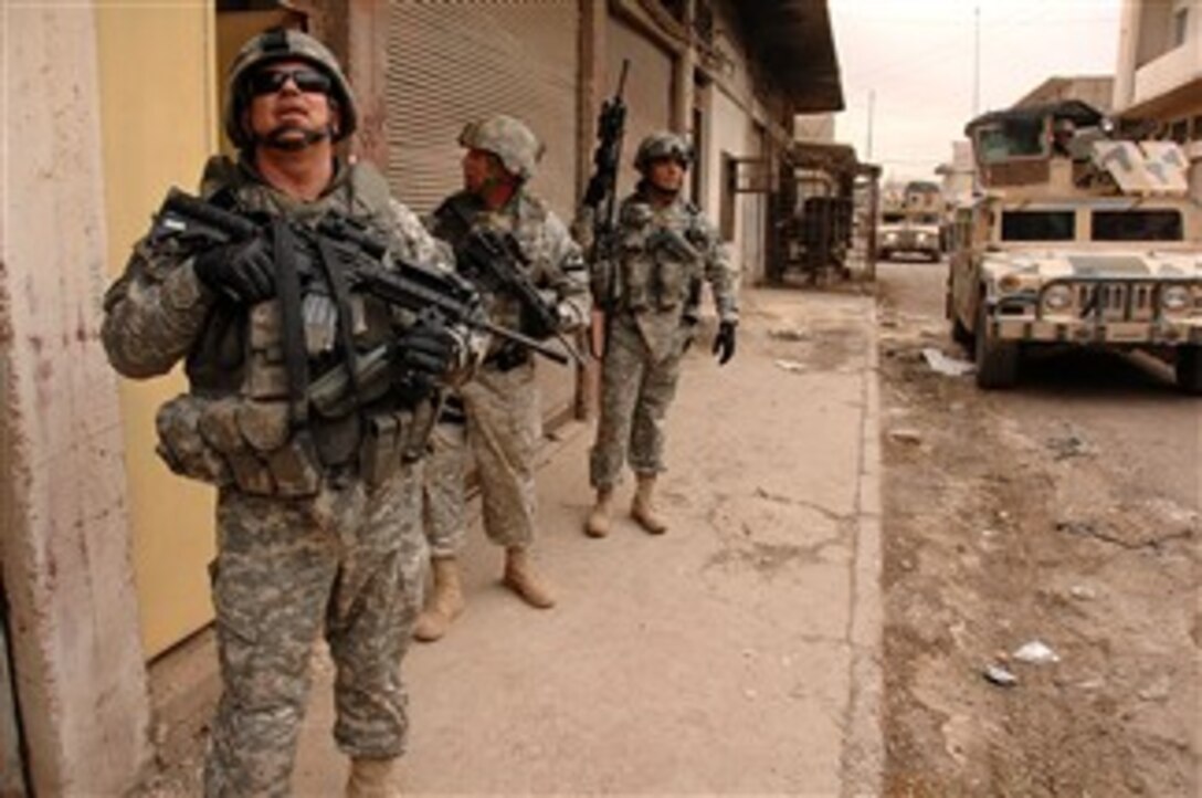 U.S. Army soldiers attached to the 2nd Iraqi Army Division Military Transition Team patrol a neighborhood in Mosul, Iraq, Dec. 1, 2007.  The U.S. soldiers work side-by-side with Iraqi soldiers in an advisory capacity.