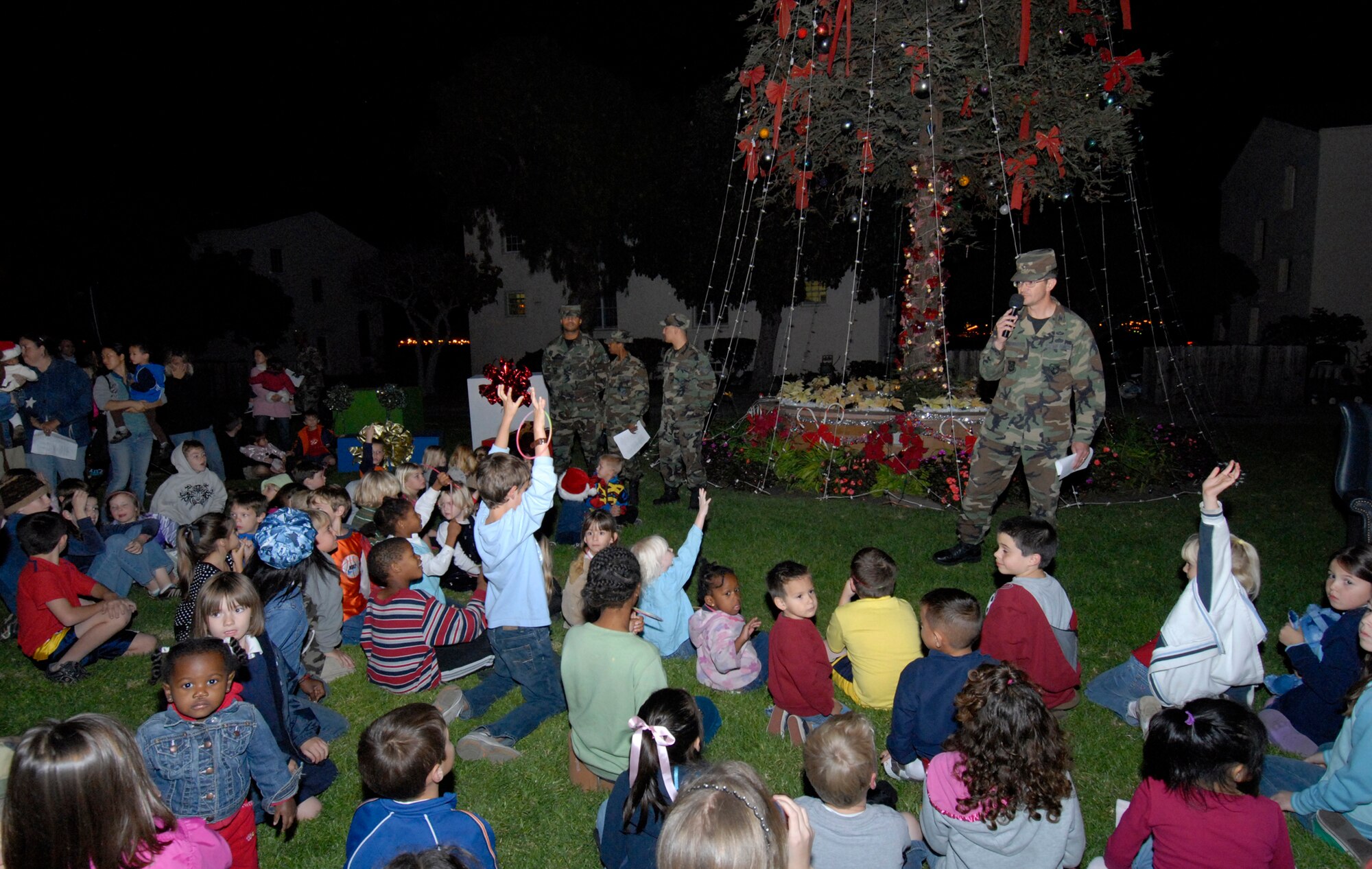 Colonel Joseph Schwarz, 61st Air Base Wing commander, talks to base children at the annual tree lighting  held on Fort MacArthur, Nov. 29. The children were waiting for a visit from Old St. Nick. (Photo by Joe Juarez)