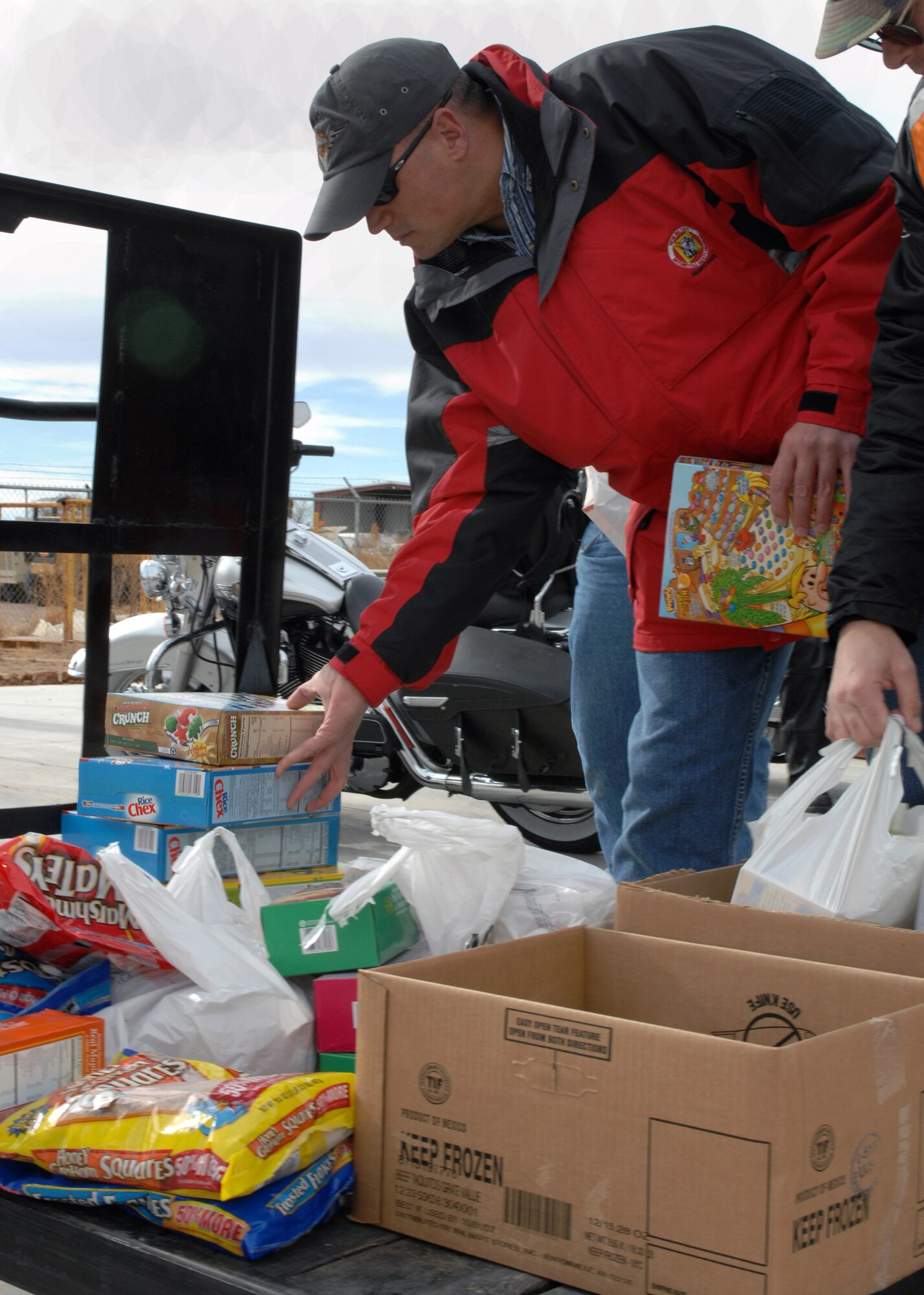 Master Sgt. Glenn Pugh stacks food on a cart at the Clovis Food Bank Dec. 6 in New Mexico. Sergeant Pugh is the 27th Special Operations Group first sergeant and a member of the motorcycle riders group at Cannon Air Force Base, N.M. The group took donated food to the food bank to share in the holiday spirit. (U.S. Air Force photo/Airman 1st Class James Bell)
