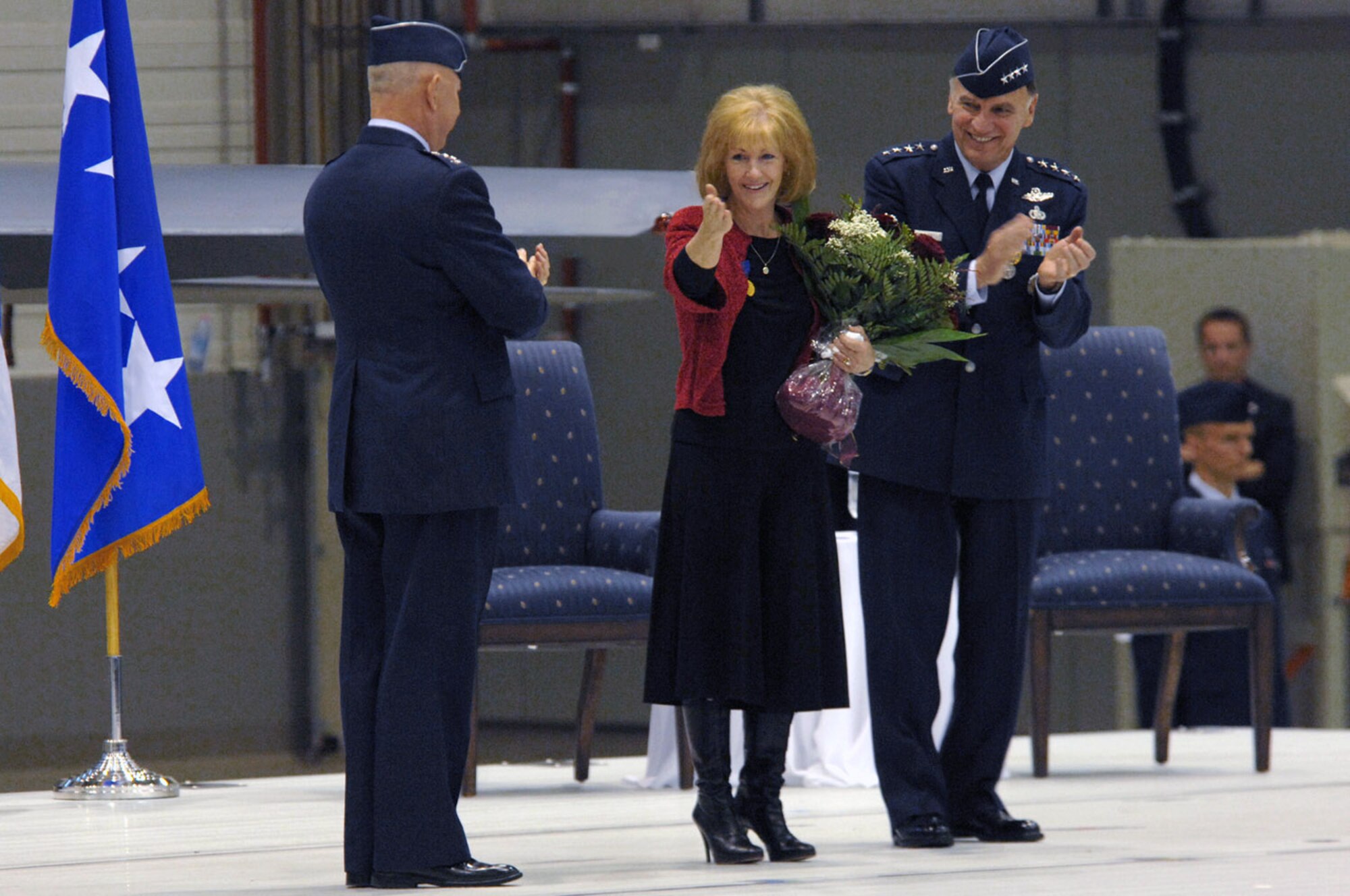 Air Force Chief of Staff Gen. T. Michael Moseley and Gen. William T.  Hobbins, U.S. Air Forces in Europe commander applauds as Robbin Hobbins says thank you with a good-bye kiss to the Ramstein family during General Hobbins' retirement ceremony Ramstein Air Base, Germany, Dec. 10.  (U.S. Air Force photo/Tech. Sgt. Kenneth Bellard)