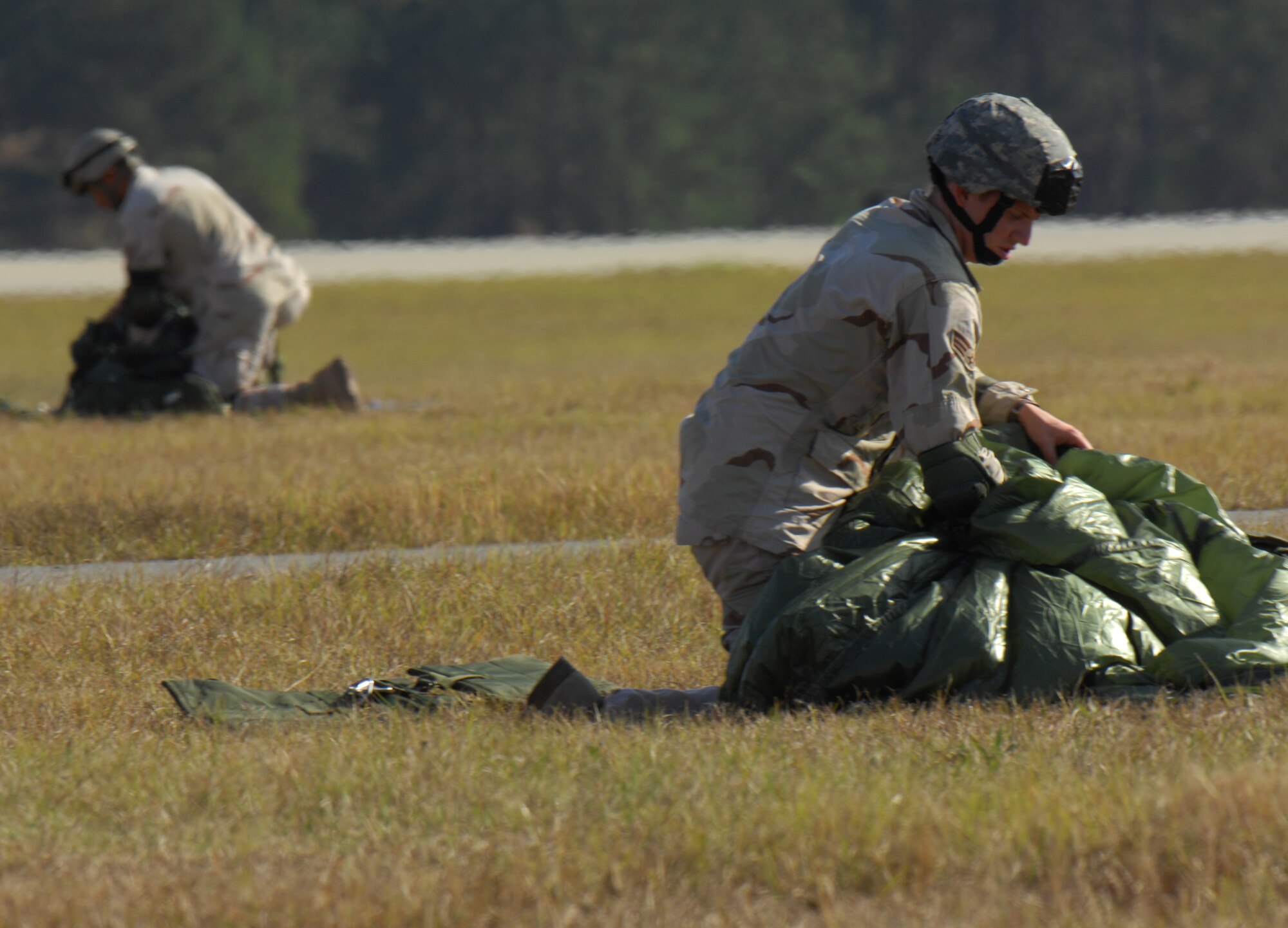 MOODY AIR FORCE BASE, Ga. — Senior Airman Ryan Cushing, 824th Security Forces Squadron fire-team leader, packs his parachute after landing during a training jump here Dec 9.  Members are required to jump monthly to maintain proficiency. (U.S. Air Force photo by Senior Airman Angelita Lawrence)


