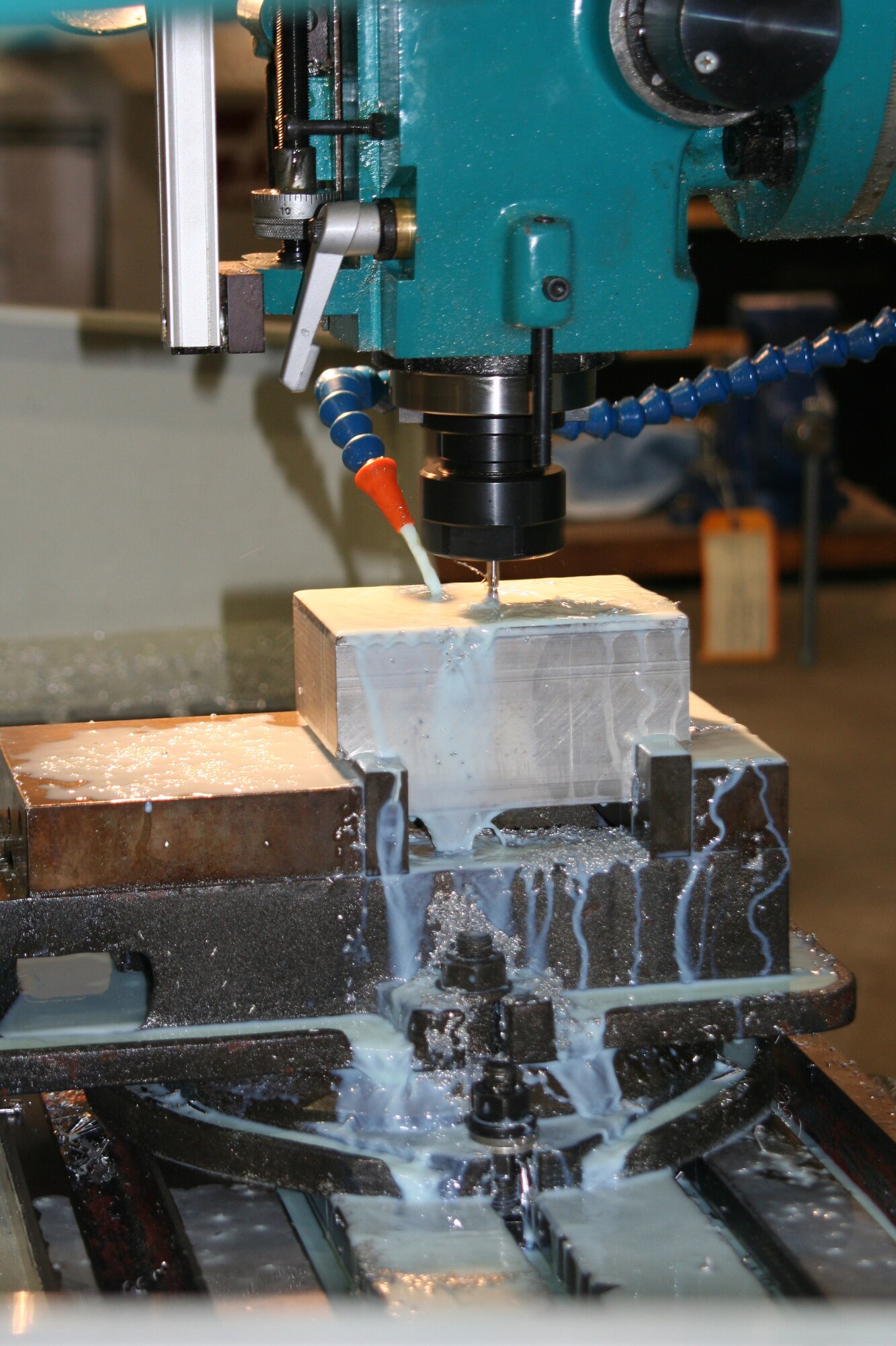 WRIGHT-PATTERSON AFB, Ohio - The 445th Maintenance Squadron's Metal Technology crew is working on a display for the Airman Leadership School.  Machining coolant, a fluid which looks like milk, is designed to to keep the drill bit sharp and free of debris and keep the metal being worked on cool. (U.S. Air Force photo/Tech Sgt. Charlie Miller) 
