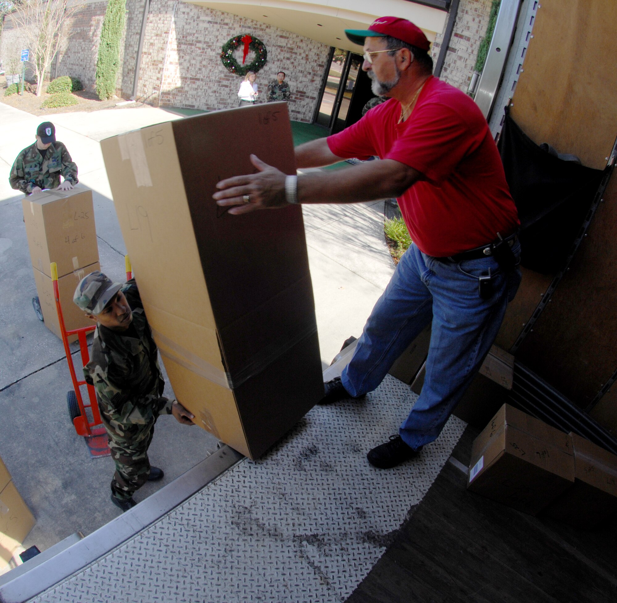 MOODY AIR FORCE BASE, Ga. — Staff Sgt. Zaire Naylor, 23rd Civil Engineer Squadron, hands Mike White, Valdosta Tech. Program Coordinator, packages Dec 6. in support of the Adopt-A-Family program in a effort to give back to the community. (U.S. Air Force photo by Senior Airman Angelita Lawrence)

