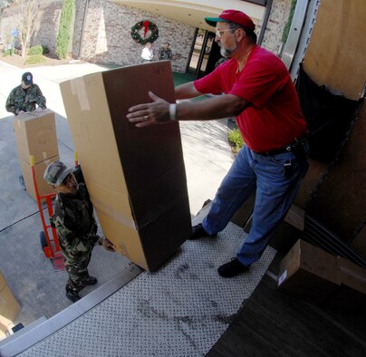 MOODY AIR FORCE BASE, Ga. — Staff Sgt. Zaire Naylor, 23rd Civil Engineer Squadron, hands Mike White, Valdosta Technical Institute program coordinator, packages Dec 6. For the past 30 years, the chapel has sponsored the event, which allows Team Moody members to give back to the local community during the holiday season. (U.S. Air Force photo by Senior Airman Angelita Lawrence) 
