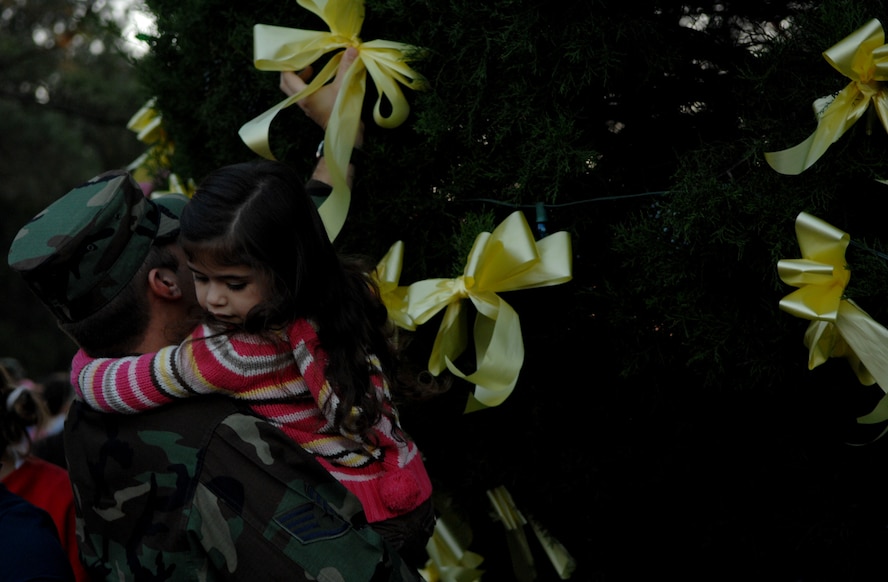 MOODY AIR FORCE BASE, Ga. -- Members of Team Moody and their family members put yellow ribbons on the base Christmas tree during a tree lighting ceremony Nov. 7. The ribbons honored Airmen deployed for the holidays. (U.S. Air Force photo by Airman 1st Class Gina Chiaverotti)