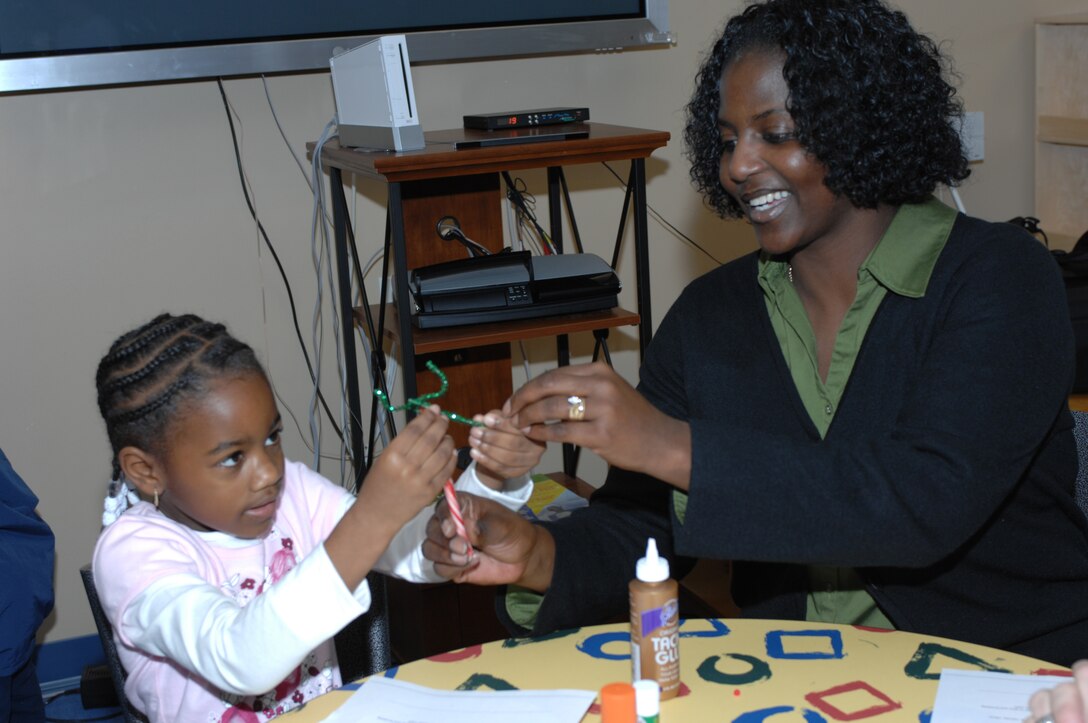 LANGLEY AIR FORCE BASE, Va. -- Ashlynn Bassett and her mother Tech. Sgt. Sevet Bassett put antlers on a candy cane reindeer during "Breakfast With Santa" Dec. 8. More than 800 people attended the event, which consisted of many activities including breakfast, writing letters to Santa and decorating ornaments. (U.S. Air Force photo/Staff Sgt. April Wickes)

