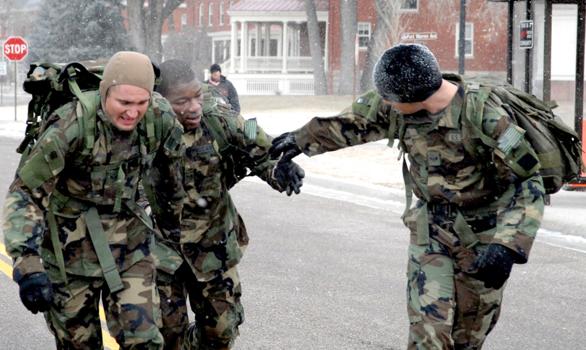 Senior Airman Thomas Hayes, Senior Airman Michael Hurd and Senior Airman Victor Noriega, 90th Tactical Response Force, help each other reach the finish line of the Chosin Reservoir Commemorative March Nov. 30. The team finished first place in the march with a time of one hour and six minutes (Photo by Shelley Raffl).