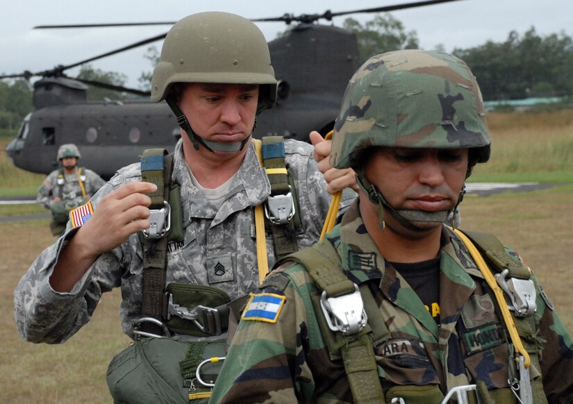 TAMARA DROP ZONE, Honduras - Army Staff Sgt. David
Hattan, Joint Task Force-Bravo Army Forces, checks the parachute of Capt.
Erwin Lara, a TESON instructor with the Honduran army, prior to an airdrop
here Dec. 8.  The air drop was the last requirement for the students in the
TESON class.  TESON, which stands for Tropas Especiales para Operaciones de
Selva y Nocturnas, is an elite Honduran unit akin to the U.S. Army Rangers.
(U.S. Air Force photo by Tech. Sgt. Sonny Cohrs)
