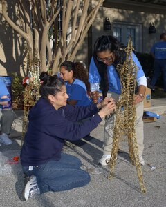 Laura Sales and Jane Balderrama assemble a grapevine motion deer for the lawn of Fisher House II on Dec. 4. Employees from local San Antonio Wal-Mart and Sam's Club stores spent the day decorating the Lackland Air Force Base and Fort Sam Houston Fisher Houses. In addition to the decorations provided by "Operation Deck the Walls," each Fisher House received $5,000 in gift cards to buy items for the houses. (USAF photo by Alan Boedeker)                               