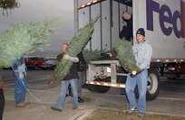 Volunteers from various squadrons on Lackland Air Force Base, Texas, unload a special delivery from FedEx on Dec. 6 - live Christmas trees. An additional 145 trees will be delivered Dec. 12. FedEx and the Christmas SPIRIT Foundation teamed together to provide approximately 20,000 trees to more than 30 military installations this year, including two in Texas, Fort Hood and Lackland AFB. (USAF photo by Alan Boedeker)                               