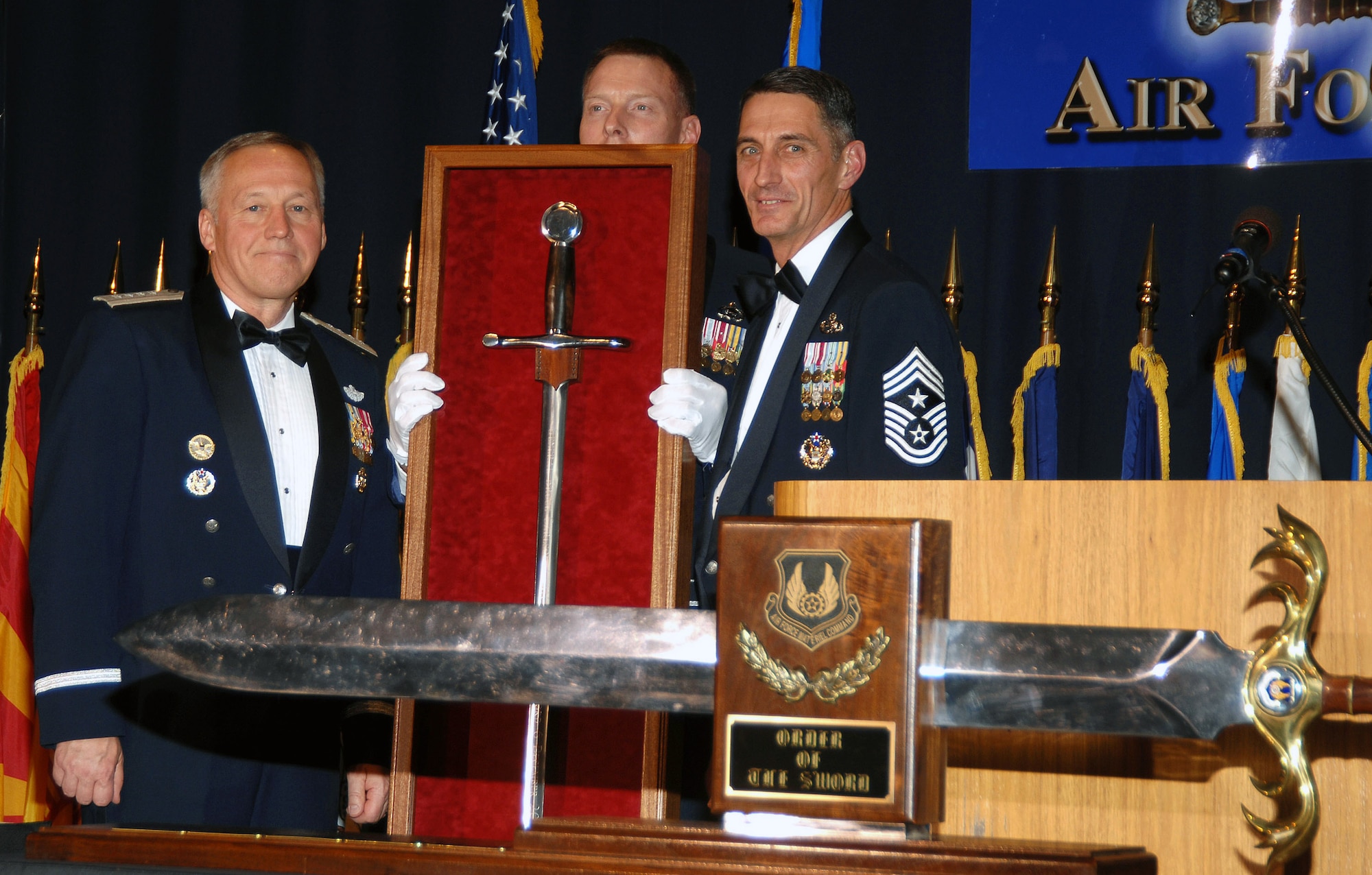 Gen. Bruce Carlson (left) is joined by the Chief Master Sgt. William Gurney, who holds General Carlson's personal sword, and Chief Master Sgt. Jonathan Hake during the Order of the Sword Ceremony Dec. 6 at the National Museum of the U.S. Air Force at Wright-Patterson Air Force Base, Ohio. General Carlson is the commander of Air Force Materiel Command, Chief Gurney was the Order of the Sword sergeant at arms for the ceremony, and Chief Hake is the AFMC command chief master sergeant. (U.S. Air Force photo/Ben Strasser) 
