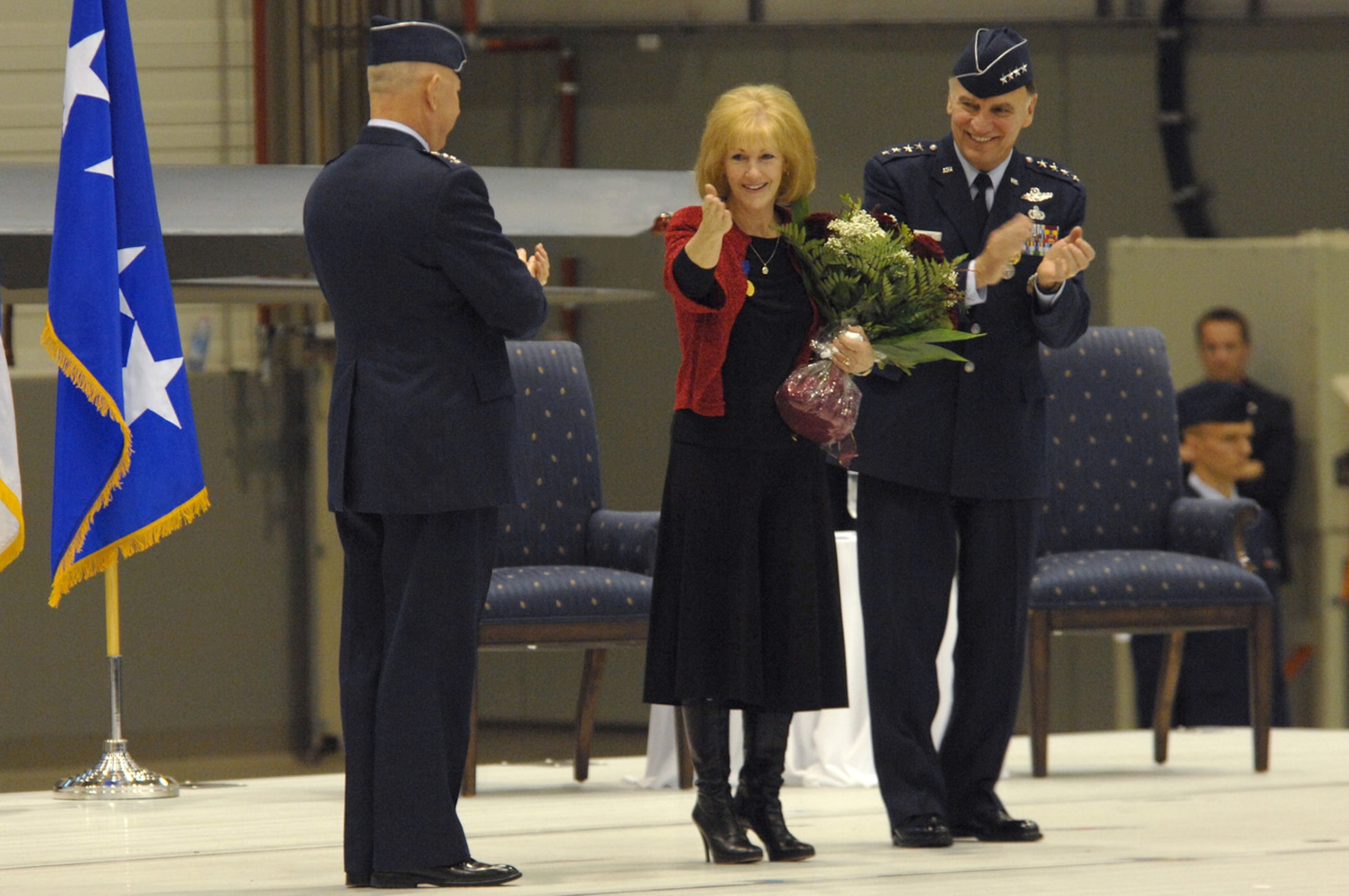 Air Force Chief of Staff Gen. T. Michael Moseley and Gen. William T.  Hobbins, U.S. Air Forces in Europe commander applaud as Robin Hobbins says thank you with a good-bye kiss to the Ramstein family during Gen. Hobbins retirement ceremony Ramstein Air Base, Germany, Dec. 10.  (U.S. Air Force photo by TSgt Kenneth Bellard)(Released).