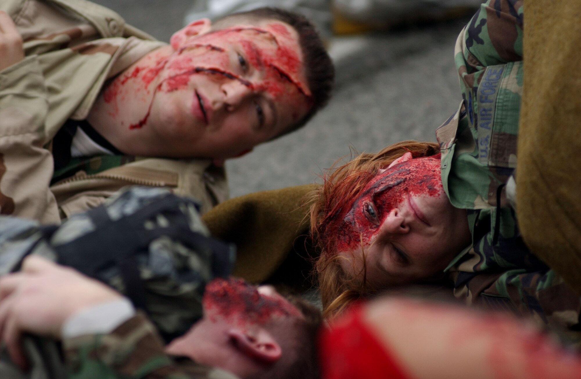 SPANGDAHLEM AIR BASE, Germany -- Senior Airman Nikola Tomic, 52nd Dental Squadron, and Airman 1st Class Michelle Moffett, 52nd Medical Support Squadron, lie among the wounded awaiting medical treatment during a simulated mass-casualty exercise held as part of a base-wide training week here. (U.S. Air Force photo/Senior Airman Matthew S. Bright)