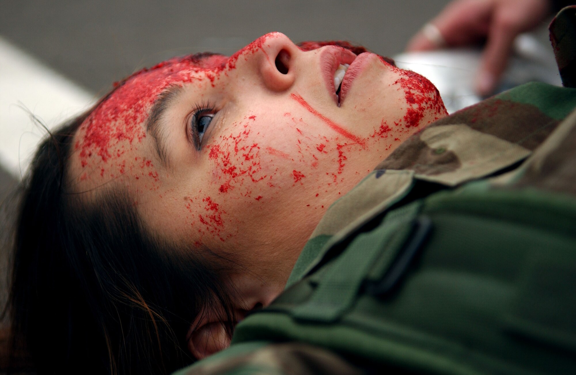 SPANGDAHLEM AIR BASE, Germany -- Airman 1st Class Sharon Powers, 52nd Dental Squadron, lies motionless while medical personnel treat her simulated wounds during a mass-casualty exercise held as part of a base-wide training week here.  (U.S. Air Force photo/Senior Airman Matthew S. Bright) 