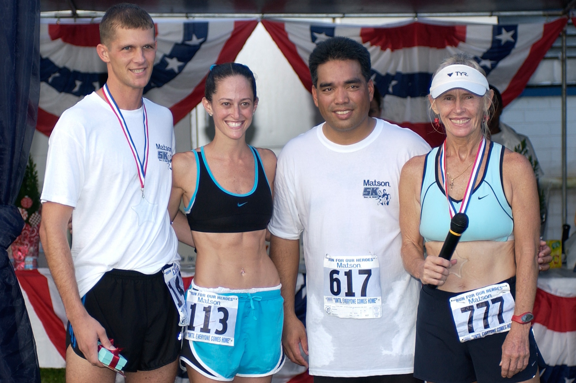 Capt. Michael Lilly (left), 36th Mobility Response Squadron, and Lisa Mason (second from left), Guam's top female runner, were awarded for being the overall first male and female finishers of the race.  (U.S. Air Force photo/Senior Airman Angelique Smythe)