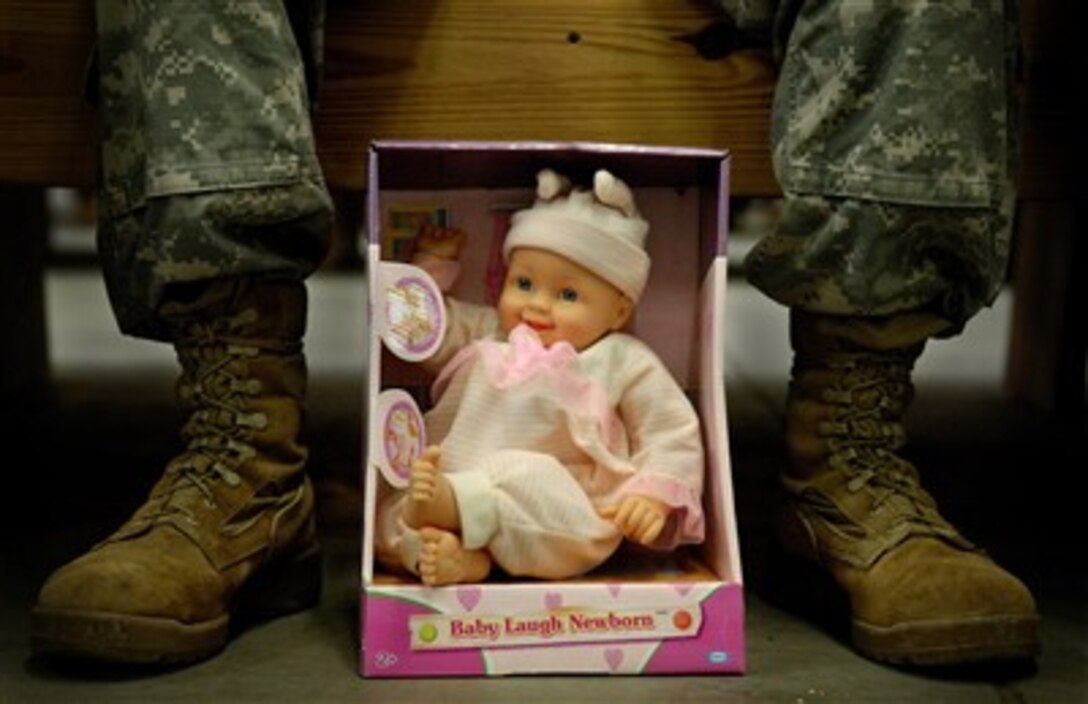 A baby doll sits at the feet of U.S. Army Sgt. Patrick Fuhrman as he waits to donate it during Operation Toy Drop at Ft. Bragg, N.C., on Dec. 8, 2007. The annual Randy Oler memorial Operation Toy Drop is a community service operation hosted by the U.S. Army Civil Affairs and Psychological Operations Command (Airborne) supporting the military and local citizens in the Fayetteville, N.C., area. 