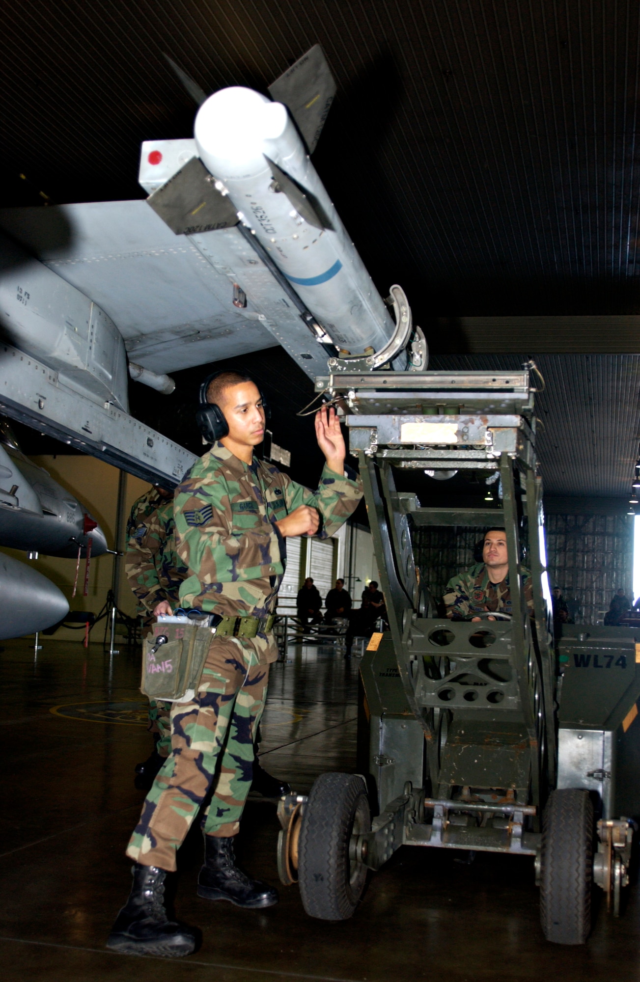 MISAWA AIR BASE, Japan -- Staff Sgt. Rolmir Garcia directs the weapons loader driver, Airman 1st Class Jose Arellano, during the annual load crew competition here, Nov 30, 2007. Both teams competing were from the 13th Aircraft Maintenance Unit.
(US Air Force photo by Airman 1st Class Eric Harris)
