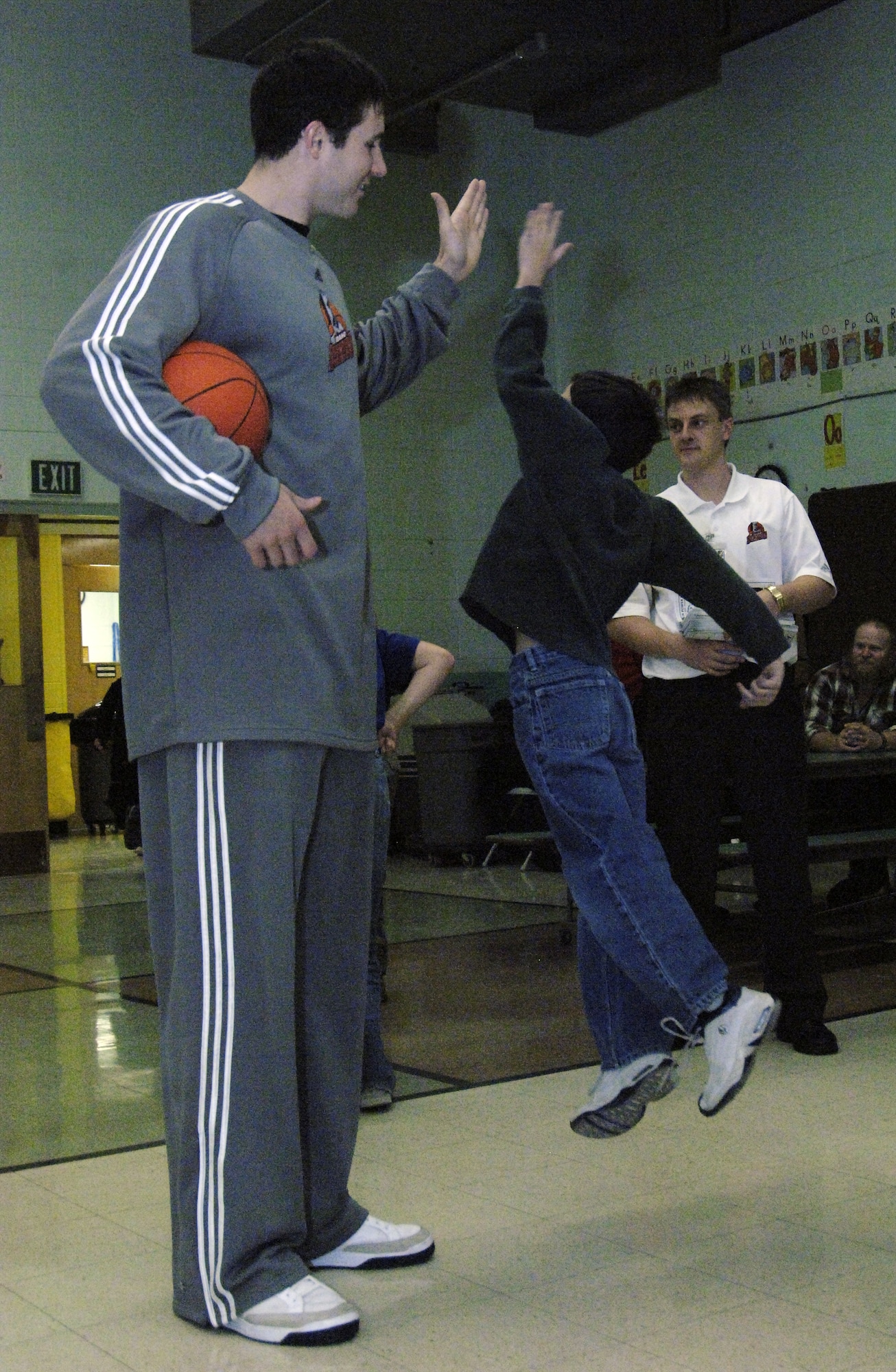 MOUNTAIN HOME AIR FORCE BASE, Idaho -- A child gives a 'high five' to Cory Violette, a member of the Idaho Stampede basketball team, at the base primary school Dec. 10. The Idaho Stampede is a member of the NBA D-league with its base of operations in Boise, Idaho. (U.S. Air Force photo/ Staff Sgt. Rodney D. Ivey)