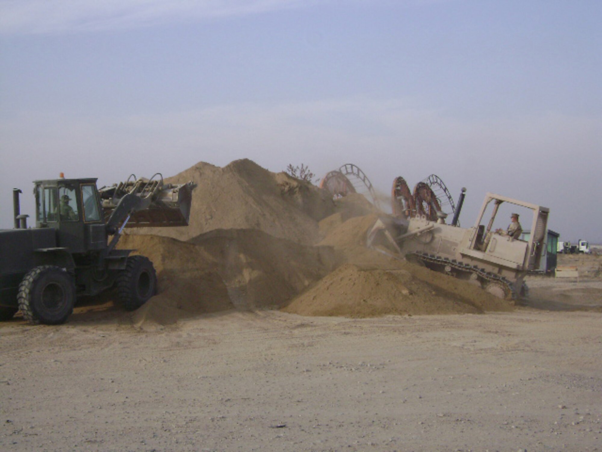 Airman 1st Class Andrew McConkay (right) in the dozer and Airman 1st Class Joshua Colwell, both from the 376th Expeditionary Civil Engineer Squadron deployed from Mountain Home Air Force Base, in the front-end loader, stock more than 1,500 tons of fill and 1,200 tons on rock while deployed to Manas Air Base, Kyrgyzstan. (Courtesy photo)
