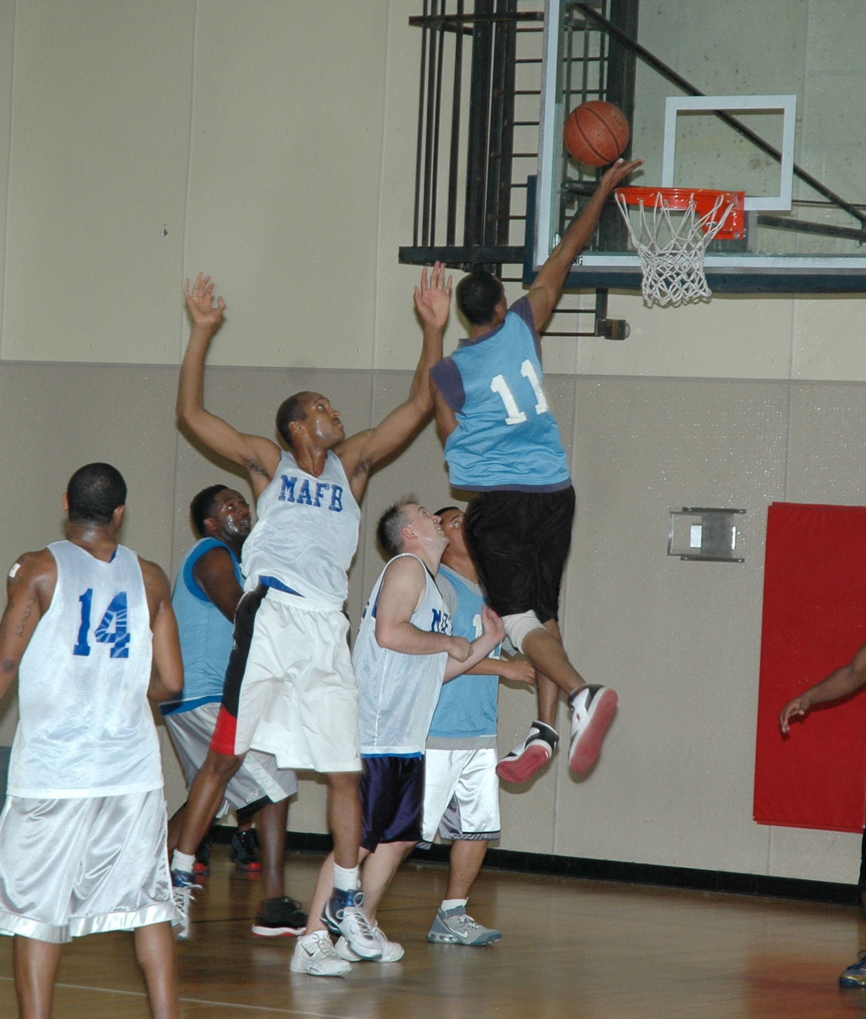 'Fire Teams' player Joshua Jones performs a lay-up against the opposing 'CE/LRS' team in the championship game of the first Hoops for the Hungry basketball tournament at the base fitness center Dec. 7. Each of the 43 players from six competing teams donated five canned goods each for entry into the tournament. Donations will be given to the Great Falls Food Bank. (U.S. Air Force photo/Airman 1st Class Dillon White)
