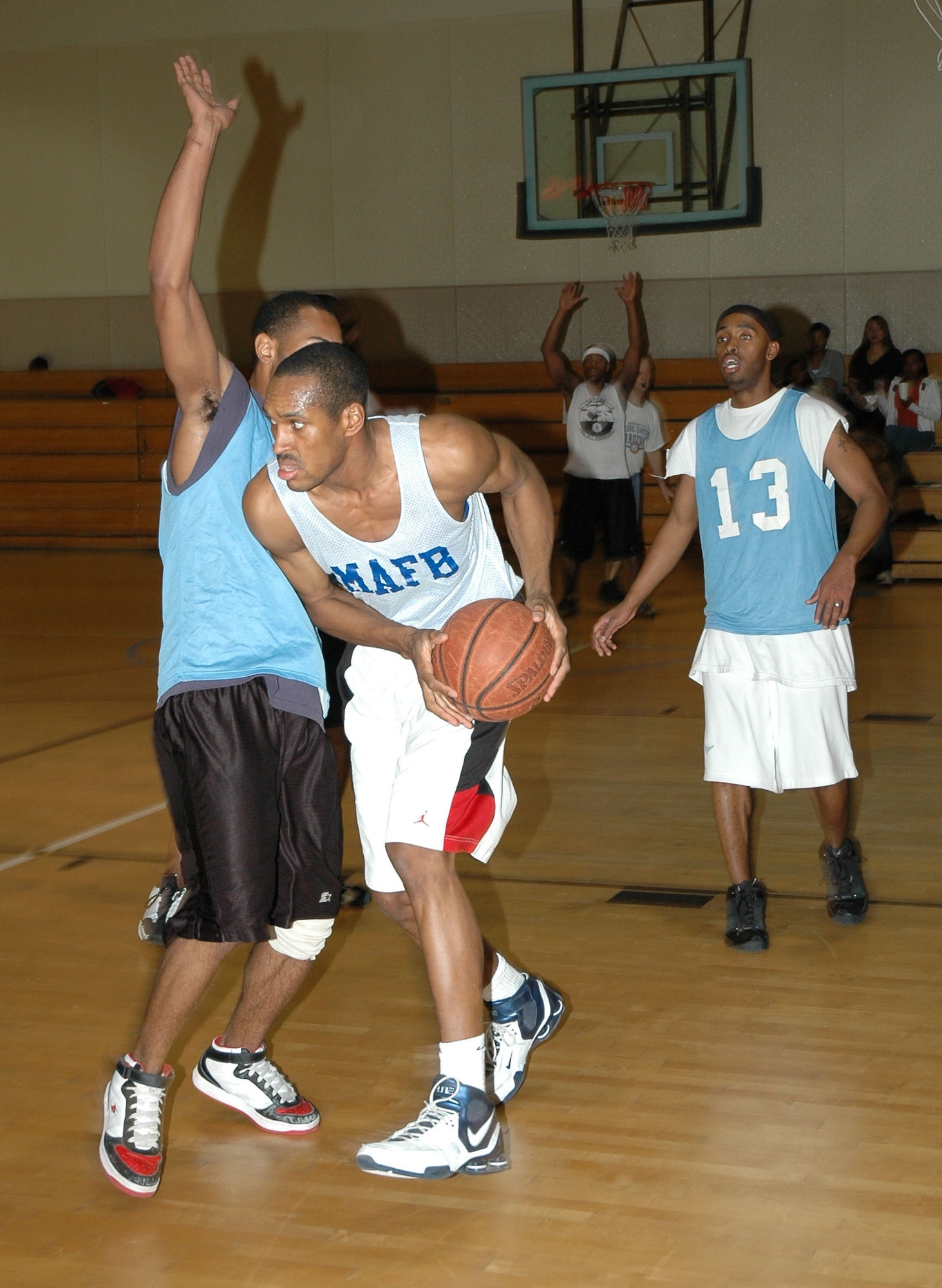 'CE/LRS' player Aharon Goins searches for an open man during the championship game of the first Hoops for the Hungry basketball tournament at the base fitness center Dec. 7. Each of the 43 players from six teams donated five canned goods for entry into the tournament. The canned goods will be given to the Great Falls Food Bank. (U.S. Air Force photo/Airman 1st Class Dillon White)