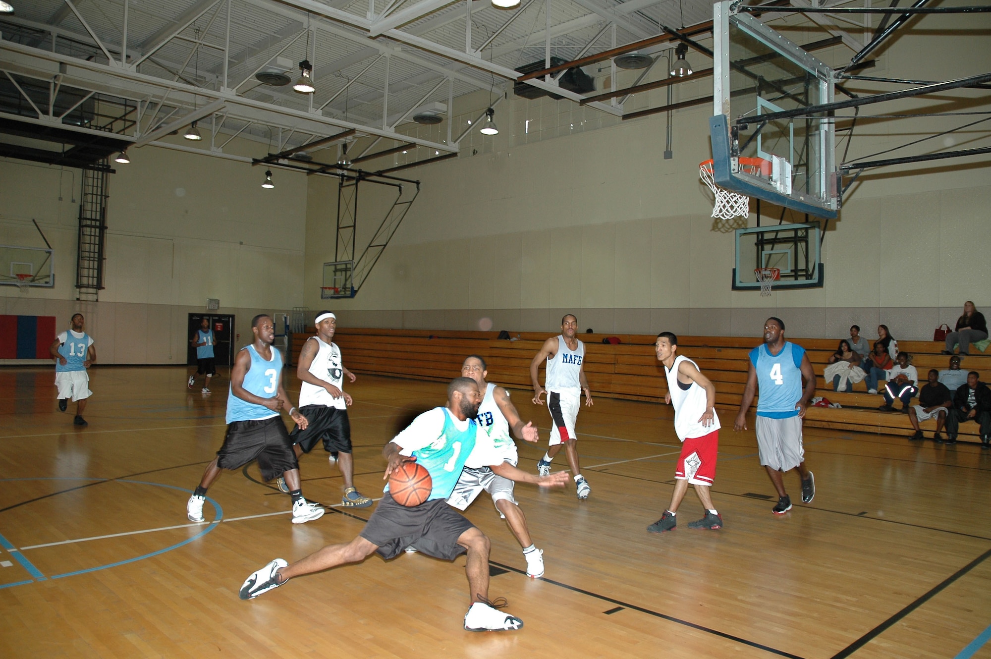 'Fire Teams' player William Marshall dribbles the ball around an opponent from the 'CE/LRS' team at the first Hoops for the Hungry basketball tournament at the base fitness center Dec. 7. Each of the 43 Airmen from six competing teams donated five canned goods each which will be given to the Great Falls Food Bank. (U.S. Air Force photo/Airman 1st Class Dillon White)