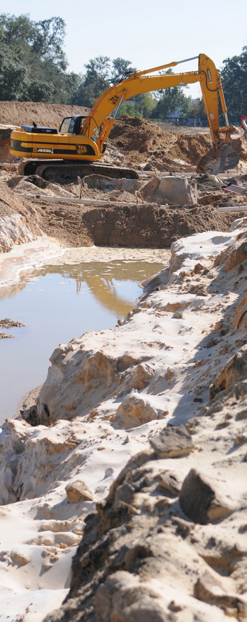 Yates Construction equipment operator Ezra Bennett uses a trackhoe to dig trenches for sewer and drainage lines in Bay Ridge.