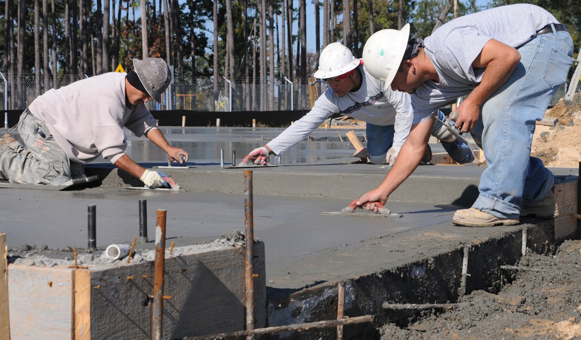 Concrete finishers Tobias Acostia, left, Alajondro Bonabadis and Octabio 
Rodriguez finish a slab in Northwest Falcon Park.  (U.S. Air Force photo by Kemberly Groue)