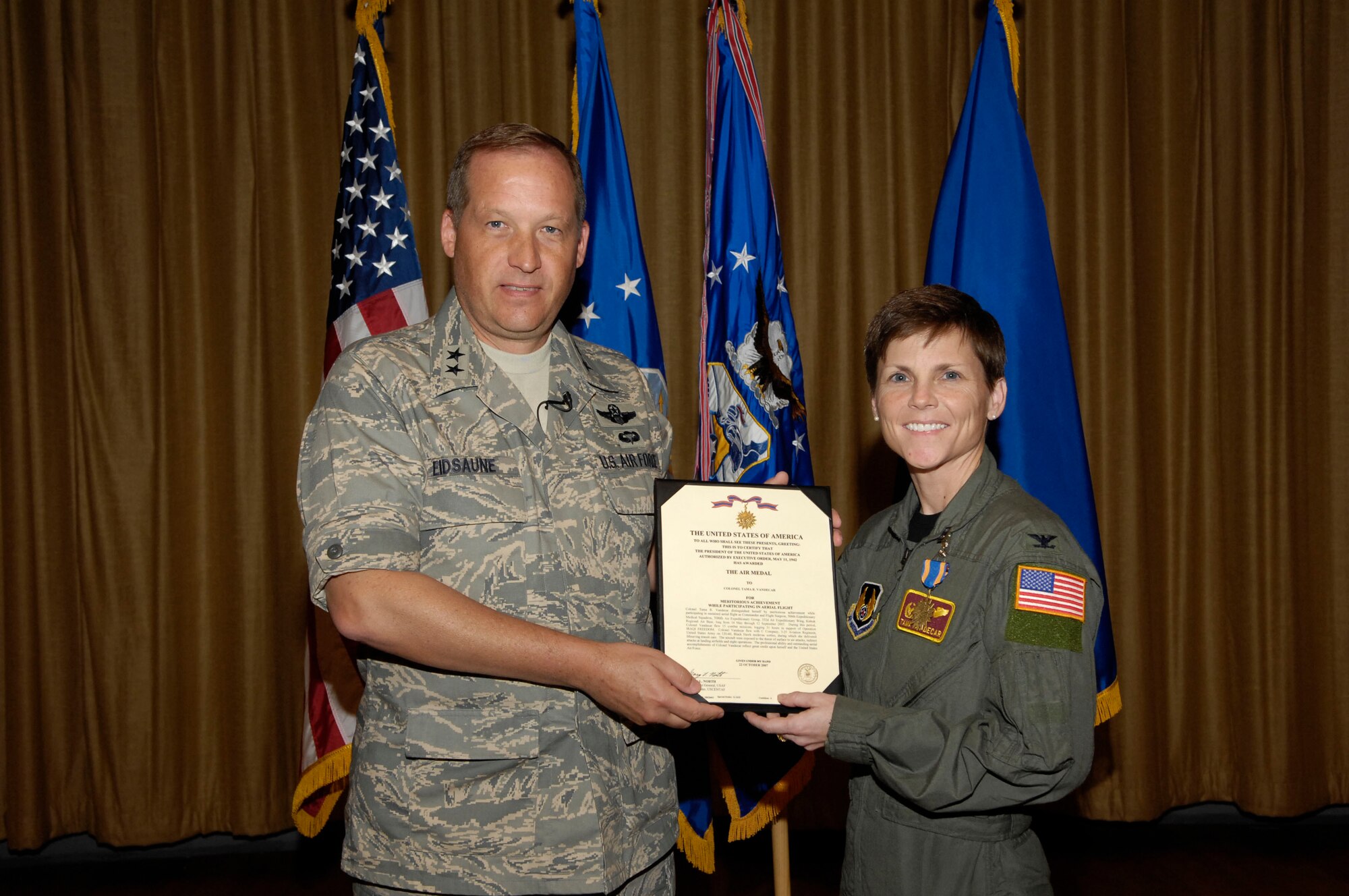 EGLIN AIR FORCE BASE, Fla.--Maj. Gen. David Eidsaune, Program Executive Officer for Weapons and Air Armament Center commander, presents an Air Medal to Col. Tama Van Decar. The colonel was recognized for meritorious achievement while deployed as the 332nd Air Expeditionary Wing's Squadron Commander and flight surgeon. (USAF photo by David Kidd)