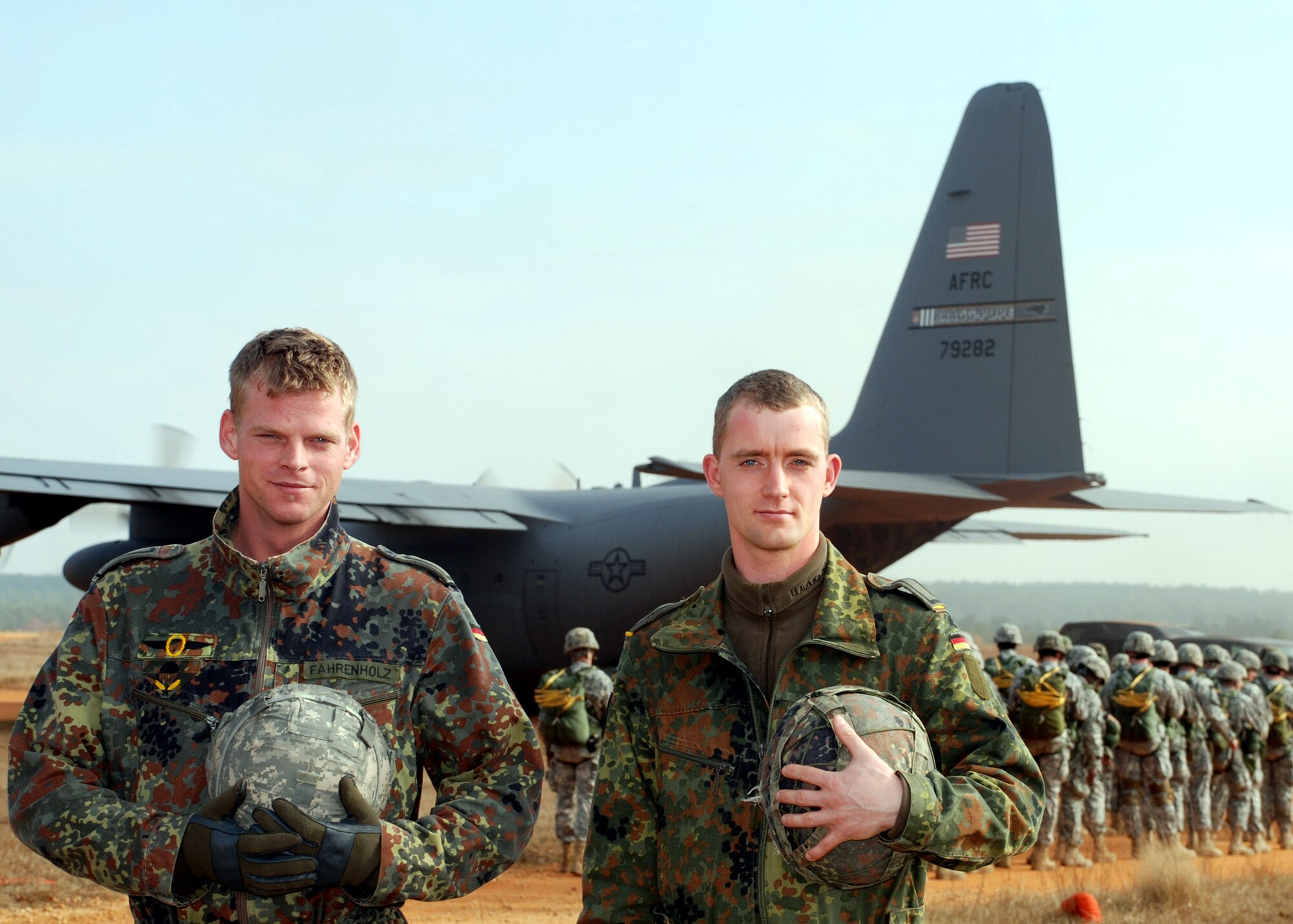 German jumpmasters Sgts.Tom Fahrenholz and Christian Rhode pause for a moment as U.S. paratroopers board an Air Force Reserve Command C-130 Hercules during Operation Toy Drop Dec. 8 at the Sicily Drop Zone at Fort Bragg, N.C. The exercise included jumpmasters from Canada, Chile and Ireland, as well as Germany.  (U.S. Air Force photo/Senior Airman Susan Parent)
