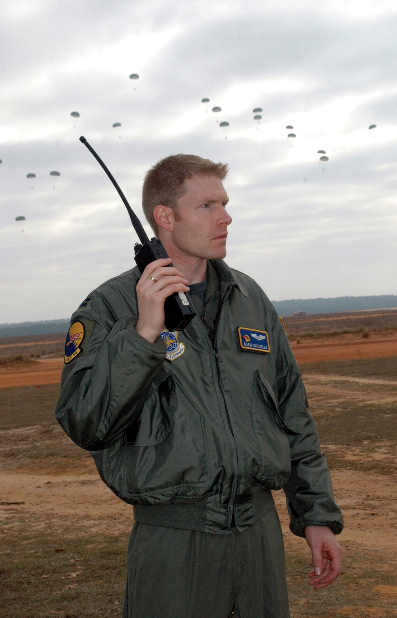Capt. Adam Shockley calls from the ground Dec. 8 during Operation Toy Drop held at the Sicily Drop Zone at Fort Bragg, N.C. The Air Force Reserve Command's 440th Airlift Wing based at Pope Air Force Base, N.C., supported the combined joint exercise with C-130 Hercules airlift. More than 1,050 paratroopers jumped during the exercise. Captain Shockley is a navigator with the 43rd Airlift Wing at Fort Bragg. (U.S. Air Force photo/Lt. Col. Ann Peru Knabe)