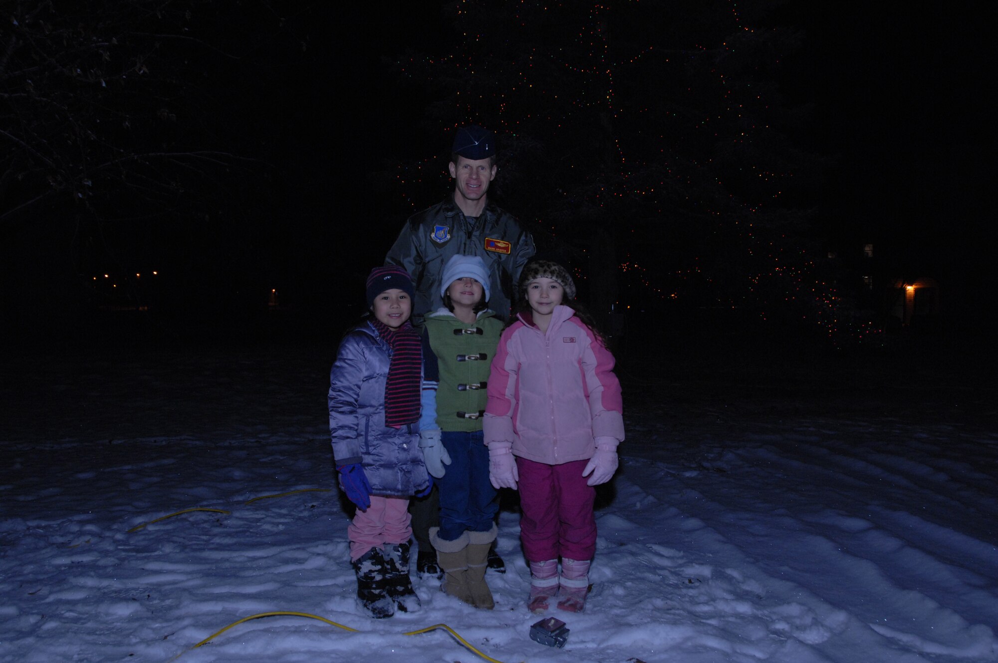 EIELSON AIR FORCE BASE, Alaska -- After the lighting of the Christmas tree, Brig. Gen. Mark Graper, 354th
Fighter Wing commander, takes a photo with Deana Seif, daughter of Tech. Sgt. Dennis Seif, Pearl Suarez, daughter of 1st Lt. Sonja Suarez, and Jacquelyn Gregoroff, daughter of Tech. Sgt. Rebecca Gregoroff, Dec. 7, 2007. The parents of the three children are currently deployed overseas fighting the war on terrorism.  (U.S. Air Force photo by Airman 1st Class Christopher Griffin)