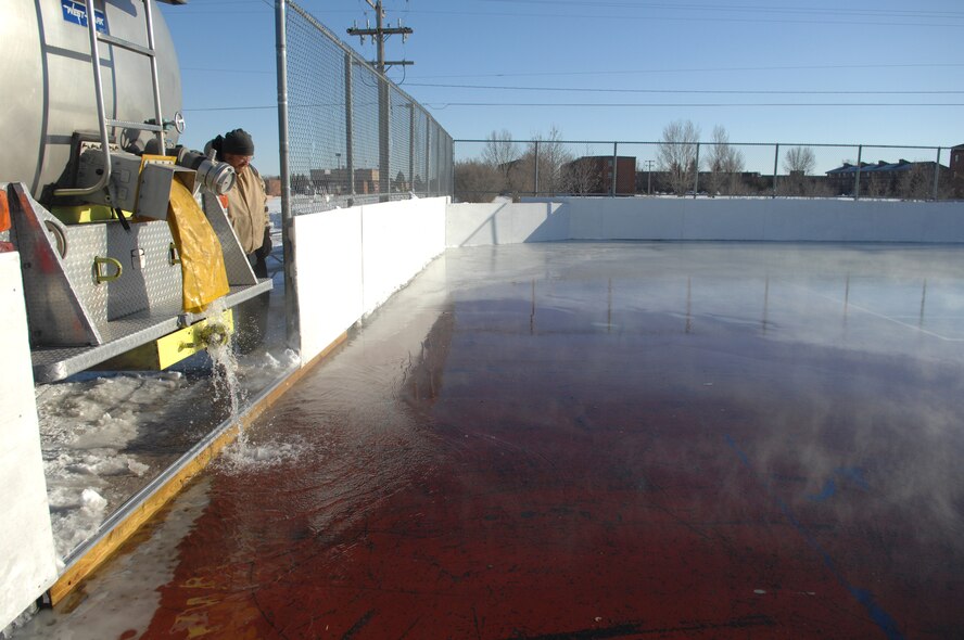 MINOT AIR FORCE BASE, N.D. -- Chris Bailey, Outdoor Recreation, looks on as the new base ice rink receives its final layer of ice Dec. 7. After three months of construction, base volunteers finished laying down the final coat of ice Dec. 7 and the new ice rink, which also doubles as a hockey rink, is ready to go. It is fully lighted, has two heavy-duty hockey goals and is open 24 hours a day, seven days a week. The rink also has safety boards surrounding the perimeter for hockey games. It is approximately half the size of a football field. (U.S. Air Force photo by Airman 1st Class Cassandra Jones)