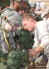 Sicily Drop Zone at Fort Bragg, N.C. -- A jumpmaster checks a soldier's parachute during Operation Toy Drop. The exercise also included jumpmasters from Canada, Chile and Ireland, and active duty and Reserve paratroopers and Airmen from the U.S. The 440th Airlift Wing, Air Force Reserve, supported the combined joint exercise with C-130 airlift. More than 1050 paratroopers jumped during the exercise. (U.S. Air Force photo/Senior Airman Susan Parent)