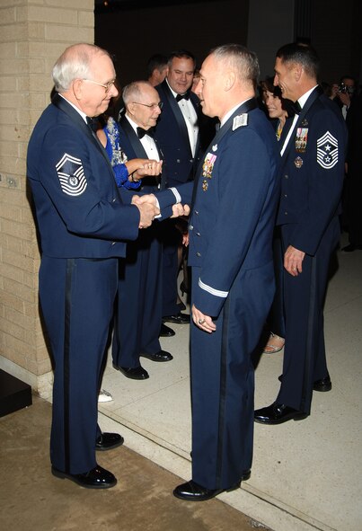 Retired Chief Master Sgt. of the Air Force Sam E. Parish (left), the eighth chief master sergeant of the Air Force, congratulates Gen. Bruce Carlson after the general's induction into the Air Force Materiel Command Order of the Sword Dec. 6.  (Air Force photo by Ben Strasser)