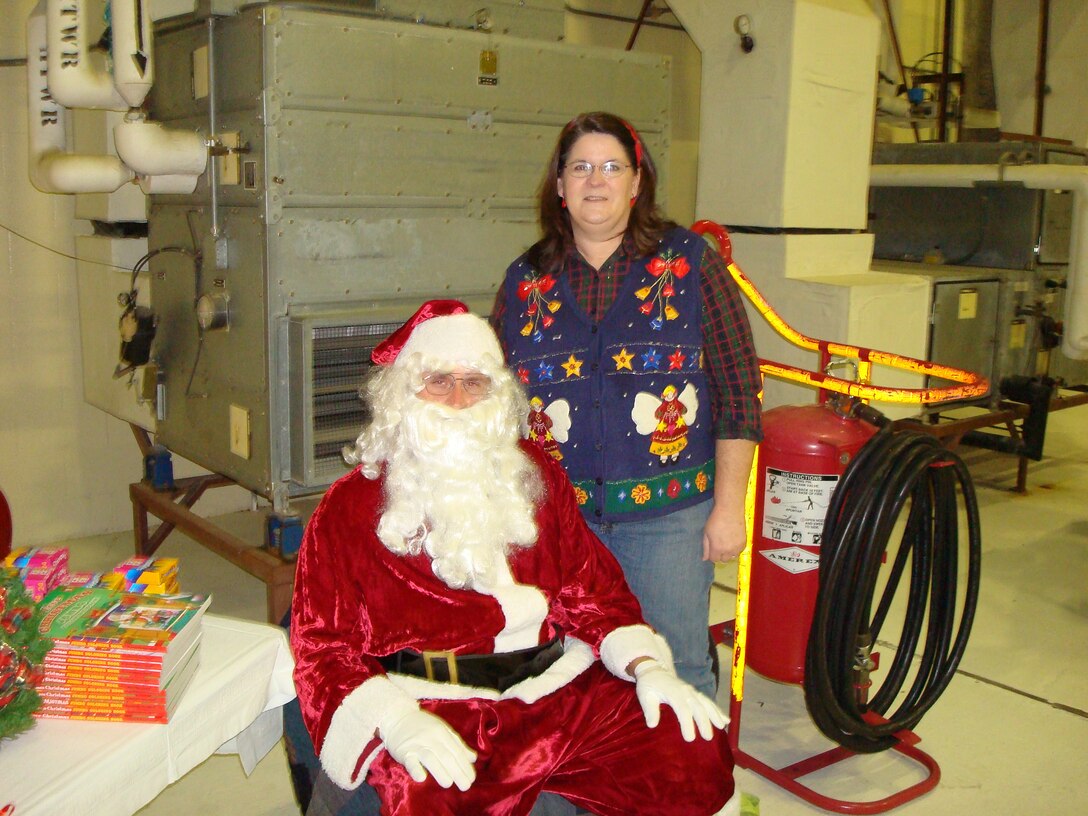 SEYMOUR JOHNSON AIR FORCE BASE, N.C. -- Santa recruited a body-double with Chief Master Sgt. Timothy Erdmann, 916th Aircraft Maintenance Squadron, during the December unit training assembly. Mrs. Erdmann stands behind her newly bearded husband as he helps supports the Maintenance Group Christmas party. More than 250 reservists enjoyed the party sponsored by the MXG Top 3.