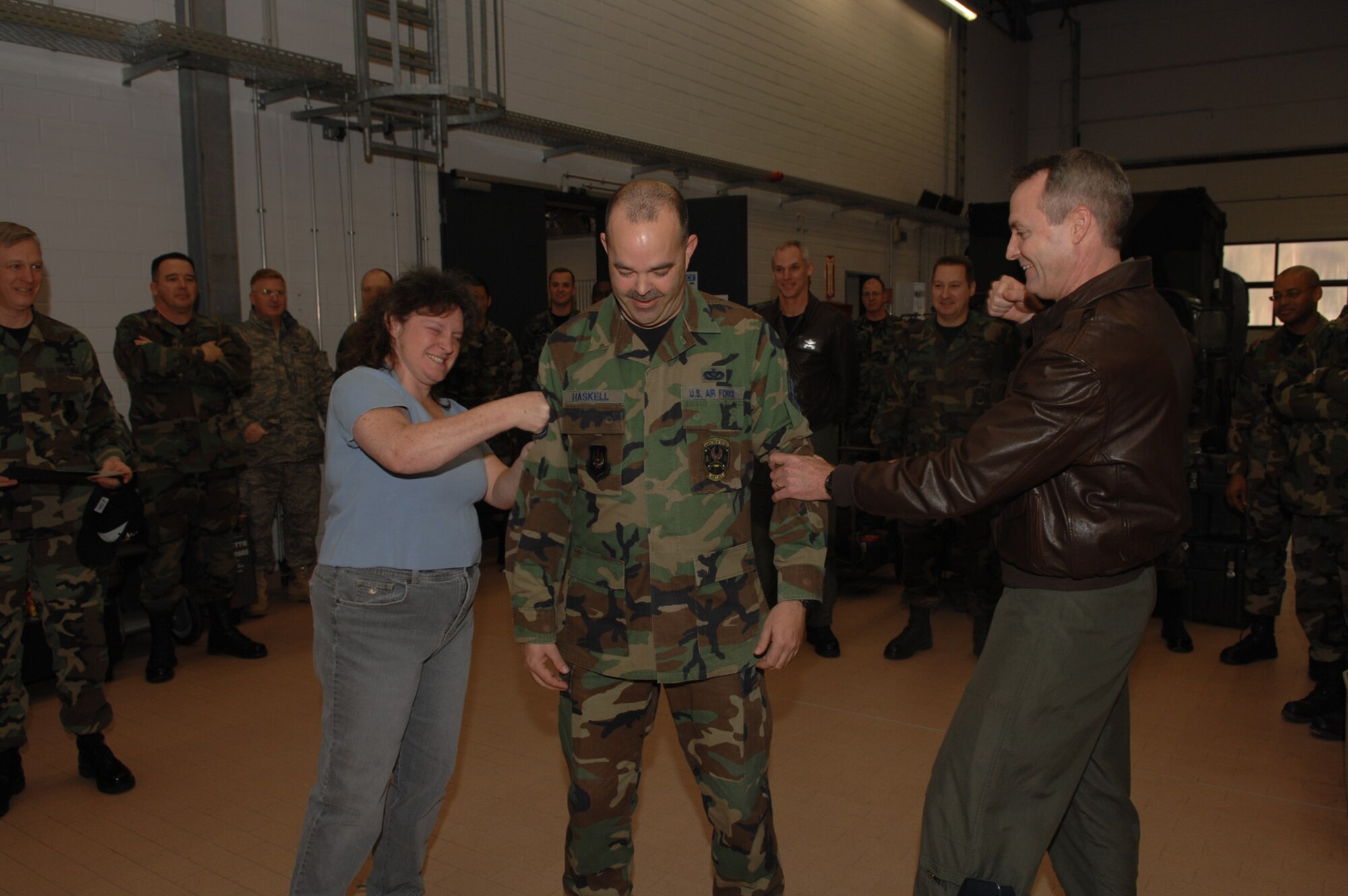 SPANGDAHLEM AIR BASE, Germany – Tech. Sgt. Douglas Haskell, 606th Air Control Squadron, has his technical sergeant strips tacked on by Dana, his wife, and Col. Darryl Roberson, 52nd Fighter Wing commander. Sergeant Haskell was promoted Dec. 11, 2007, through the Stripes Through Exceptional Performance program. (U. S. Air Force photo/Airman 1st Class Allen Pollard)