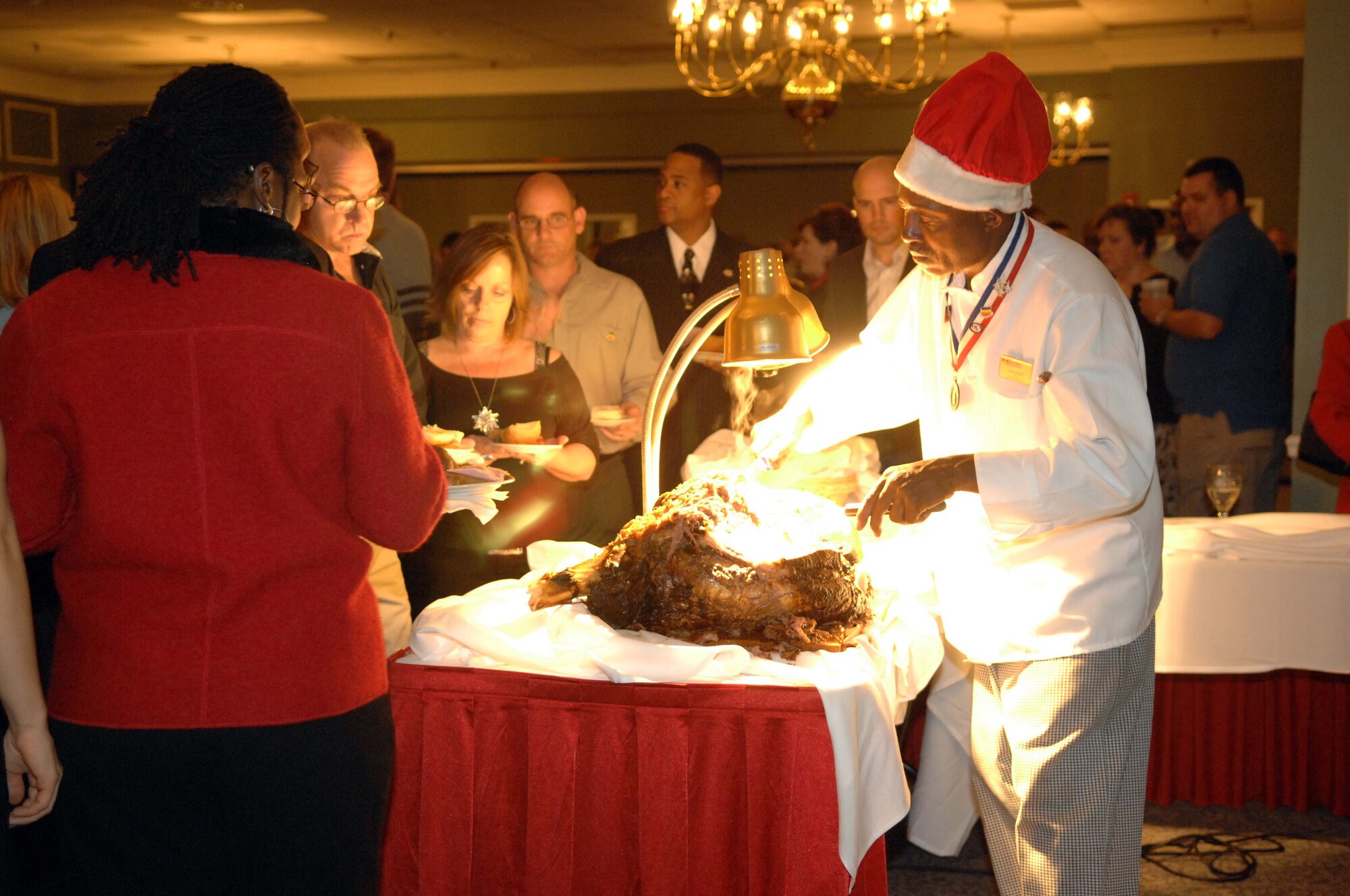SHAW AIR FORCE BASE, S.C. -- Calvin Brooks, Carolina Skies Club Chef, serves ham and other meats to attendees of the 2007 20th Fighter Wing Holiday Reception Dec. 8. The party, attended by thousands of Shaw members,  featured new menus of appetizers, hors d'oeuvres and desserts from the Carolina Skies kitchen.(U.S. Air Force photo/Airman 1st Class Kathrine McDowell)