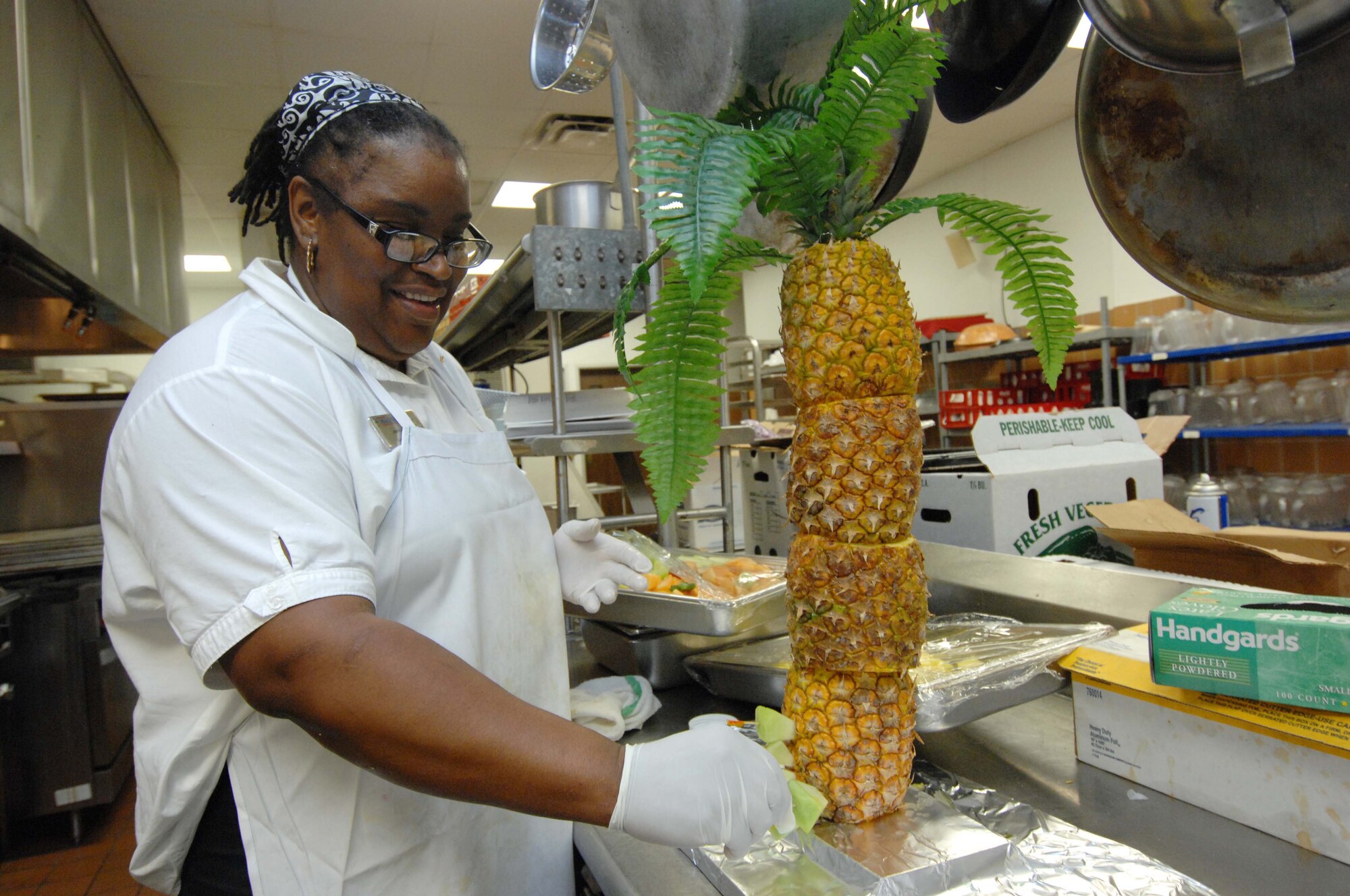 SHAW AIR FORCE BASE, S.C. -- Janice Garrett, Carolina Skies Club kitchen supervisor, begins decorating a pineapple palm tree with tropical fruit Dec. 8 for the 2007 20th Fighter Wing Holiday Reception. The party, attended by thousands of Shaw members, featured new menus of appetizers, hors d'oeuvres and desserts from the Carolina Skies kitchen. (U.S. Air Force photo/Airman 1st Class Kathrine McDowell)