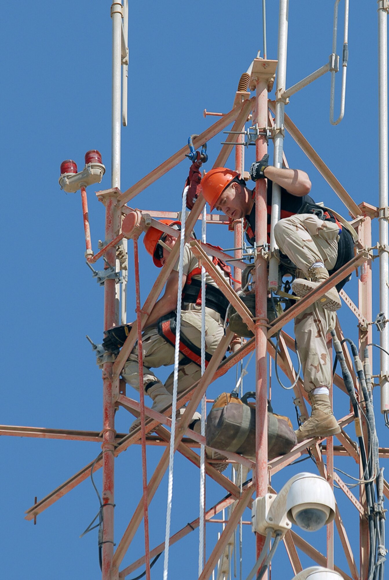 SOUTHWEST ASIA - Airman First Class  Robert Bowley and Staff Sgt. Charles Austin, 379th Expeditionary Communications Squadron, install a new antenna atop a one-hundred-fifty foot tower at a Southwest Asia air base Dec. 8. Airman Bowley is deployed from Andrews Air Force Base AFB, Md. Sergeant Austin is deployed from Lackland AFB, Texas. (U. S. Air Force photo by Staff Sgt. Douglas Olsen)