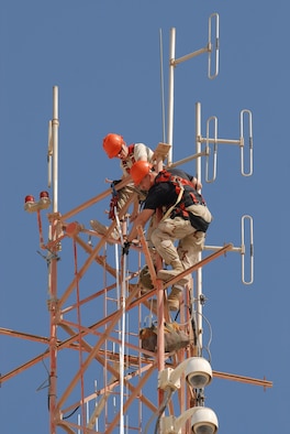 SOUTHWEST ASIA - Airman 1st Class Robert Bowley and Staff Sgt. Charles Austin, 379th Expeditionary Communications Squadron, install a new antenna atop a one-hundred-fifty foot tower at a Southwest Asia air base  Dec. 8. Airman Bowley is deployed from Andrews Air Force Base AFB, Md. Sergeant Austin is deployed from Lackland AFB, Texas. (U. S. Air Force photo/Staff Sgt. Douglas Olsen)