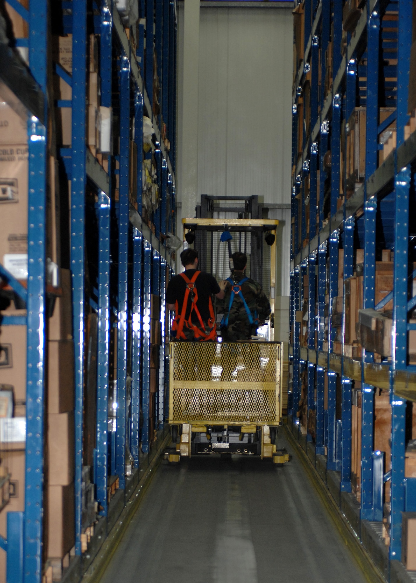SPANGDAHLEM AIR BASE, Germany – (Left to right) Airman 1st Class Tanner Falvella and Airman Aaron Cox, both from the 52nd Logistics Readiness Squadron, drive a forklift through the largest warehouse on Spangdahlem Air Base Dec. 10, 2007. (U.S. Air Force photo/Airman 1st Class Jenifer Calhoun)